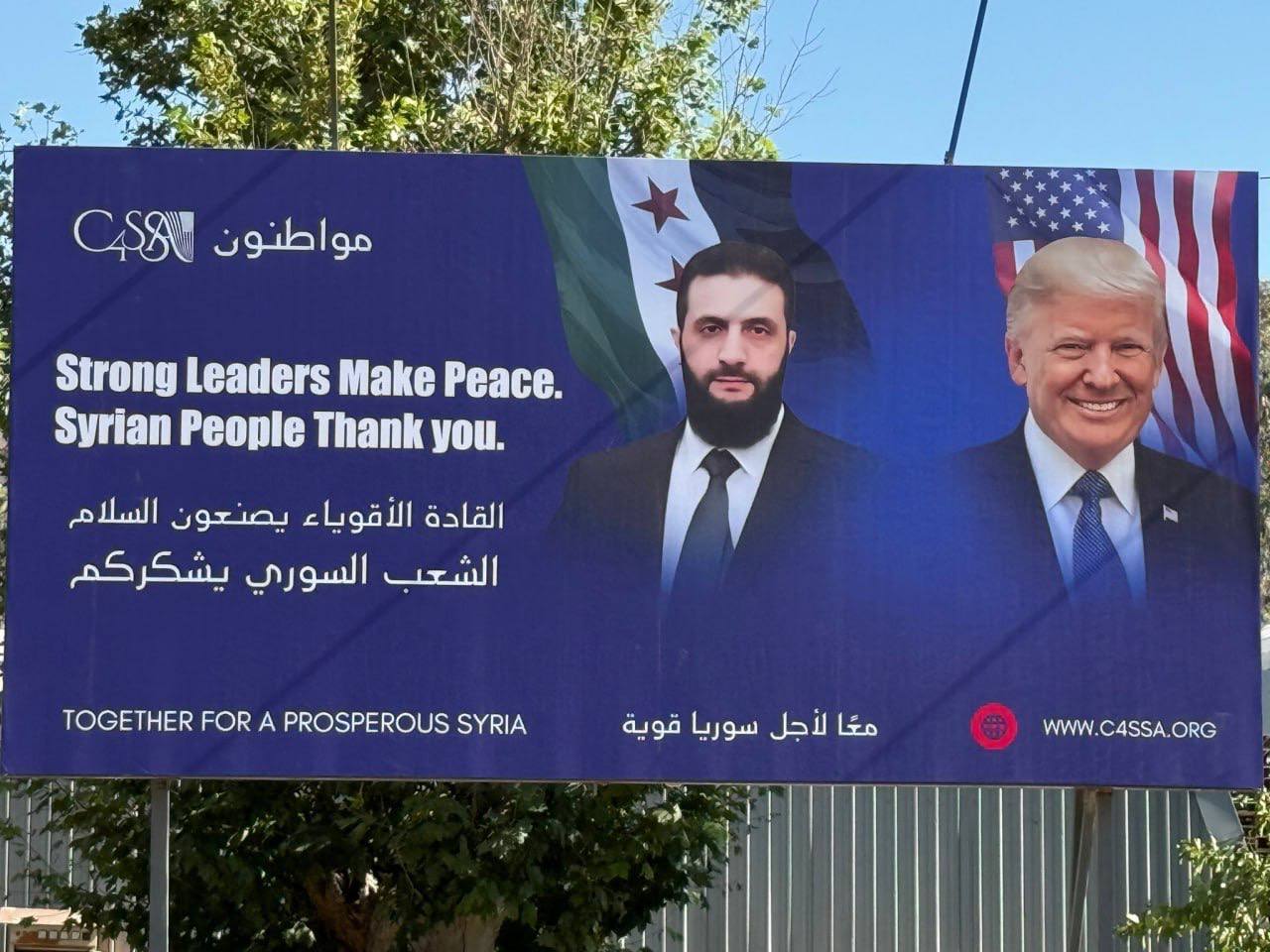 В Дамаске установили плакат с изображением президентов Сирии и США. Позже местные жители зарисовали лицо Трампа. Баннер разместила Организация Citizens for a Secure and Safe America C4SSA . На сайте организации сообщается «наша миссия — способствовать демократическим изменениям в Сирии, чтобы её граждане могли жить в свободной, светской и процветающей стране» Важно отметить, что сирийцев приучали ненавидеть Америку ещё со времен правления режима Асада. Антиамериканизм стал частью государственной пропаганды и инструментом удержания власти Nasledie News