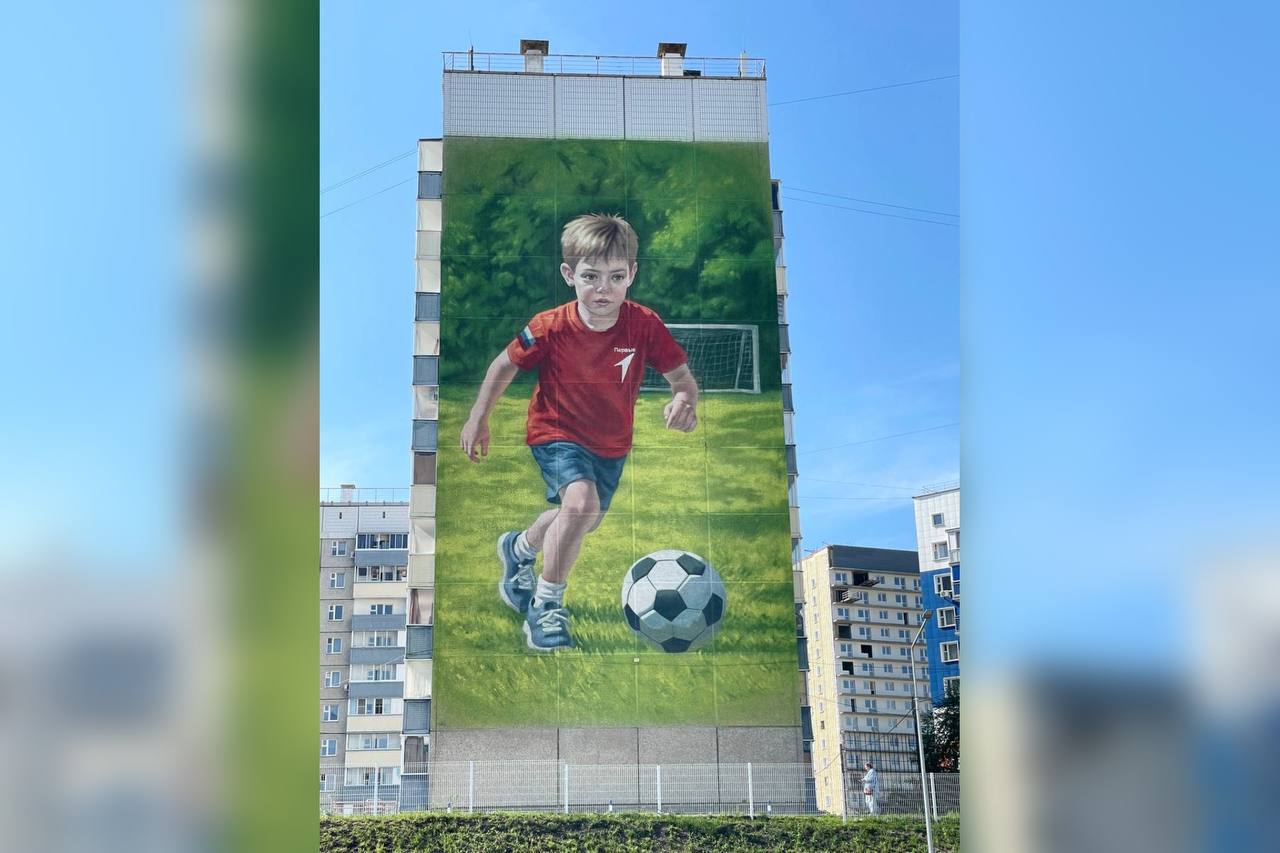 В Красноярске появился новый мурал На этот раз - в микрорайоне Солнечный. На торце дома по адресу: проспект Молодежный, 23 художники изобразили играющего в футбол мальчика в форме с эмблемой «Движения первых». Фасад многоэтажки выходит прямо на футбольное поле. На данный момент в краевом центре более 20 муралов. По словам руководителя агентства печати и массовых коммуникаций края Ирины Брежневой, вскоре начнется работа над очередным - в этот раз в микрорайоне Пашенный. Ирина Брежнева