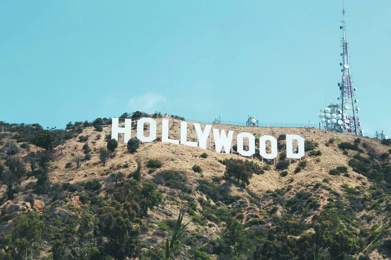 Звезды Голливуда протестуют против слияния Warner Bros Discovery и Paramount Более тысячи голливудских сценаристов актёров и режиссёров включая Брайана Крэнстона Хоакина Феникса и Дени Вильнёва подписали письмо против сделки по приобретению Warner Bros Discovery компанией Paramount Авторы обращения говорят о том что слияние двух крупнейших студий нанесёт новый удар по и без того кризисной индустрии развлечений По их мнению сделка приведёт к сокращению числа фильмов и уменьшению рабочих мест для творческих специалистов В письме подчёркивается что могущественные корпорации диктуют свои условия оставляя независимых авторов без работы Парадоксально но глава Paramount Дэвид Эллисон настаивает на обратном он обещает выпускать не менее 30 фильмов в кинотеатрах ежегодно и сохранить независимое творческое руководство студий Авторы письма призвали генпрокурора Калифорнии Роба Бонту продолжить изучение вопроса заявив о готовности вступить в борьбу за живое будущее индустрии Источник The New York Times Фото Nathan DeFiesta Unsplash Telegram VK MAX