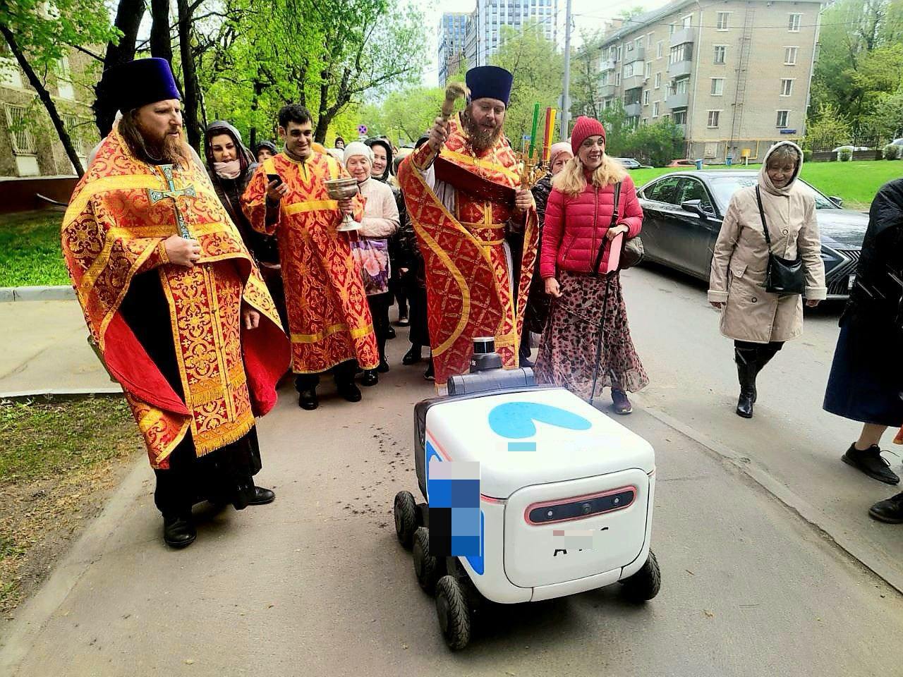 «От святой воды хуже никому не будет, даже роботу». В московском храме объяснили освящение робота-доставщика. В соцсетях распространилось фото со священниками Храма Благовещения Богородицы в Петровском парке, которые окропили святой водой пластикового курьера. В самой церкви рассказали изданию «Подъём», что специально не задумывали такую акцию, это была импровизация, робот просто оказался на пути крестного хода. «Да это он случайно, конечно, там оказался. Они просто бегают по дорогам. У нас никакого робота-доставщика нет, они по территории у нас вообще не ездят, он просто мимо проходил. Это случайно, ничего такого. Роботы-доставщики везде сейчас ходят. У нас после Пасхи встречаются два храма: из храма Митрофана Воронежского крестный ход идёт и встречается с нашим храмом Благовещения, и потом мы вместе идём сюда на территорию, здесь молебен проводим. Это каждый год так после Пасхи в субботу. А это просто робот-доставщик, видно, мимо проезжал и попал. Импровизация такая получилась. От святой воды хуже никому не будет, даже роботу-доставщику». В храме добавили, что еда внутри робота после окропления считается освящённой. Там пошутили, что получатели заказов теперь «покрестятся и станут православными». Подписывайтесь на «Подъём»!