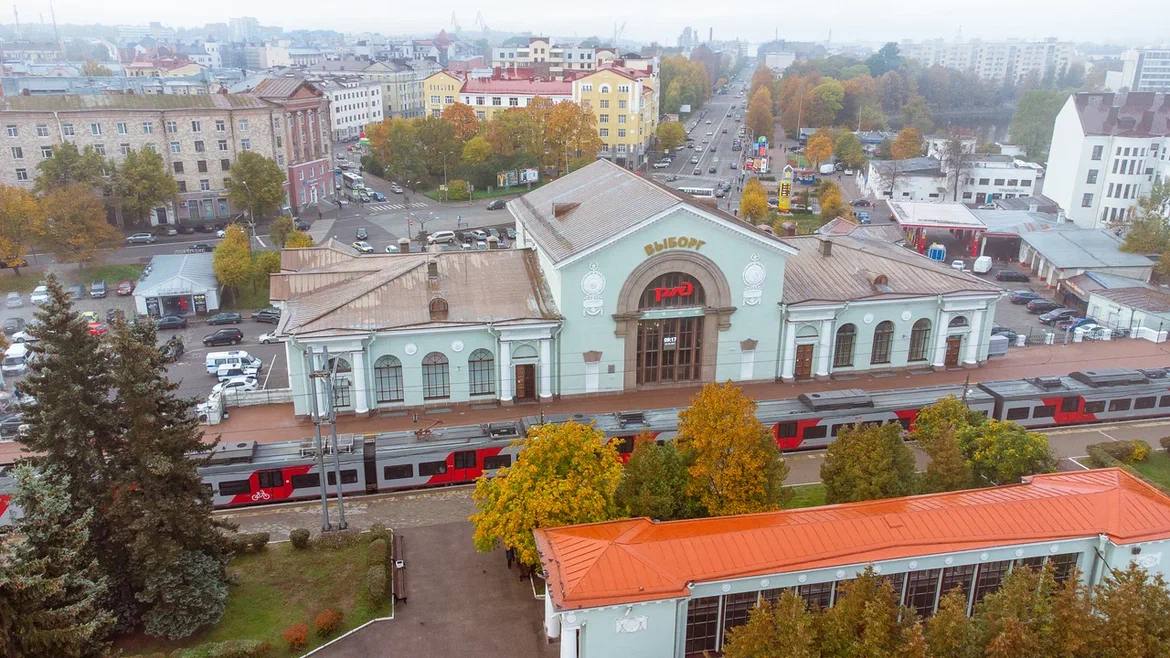 Выборгскому вокзалу 72 Современный железнодорожный вокзал в Выборге был построен в стиле сталинского ампира и распахнул свои двери для пассажиров в октябре 1953 года Сегодня выборгский вокзал принимает и отправляет поезда курсирующие в направлении Санкт Петербурга Москвы и Петрозаводска Ежедневно через вокзальный комплекс проходит около 5 6 тыс пассажиров   Отметим что железнодорожная история Выборга началась еще в 1869 году первый вокзал был возведен к открытию ветки Санкт Петербург Гельсингфорс ныне Хельсинки Спустя сорок лет в 1913 году построили новое здание вокзала по проекту финских архитекторов Элиэля Сааринена и Германа Гезелиуса которое было разрушено во время Великой Отечественной войны