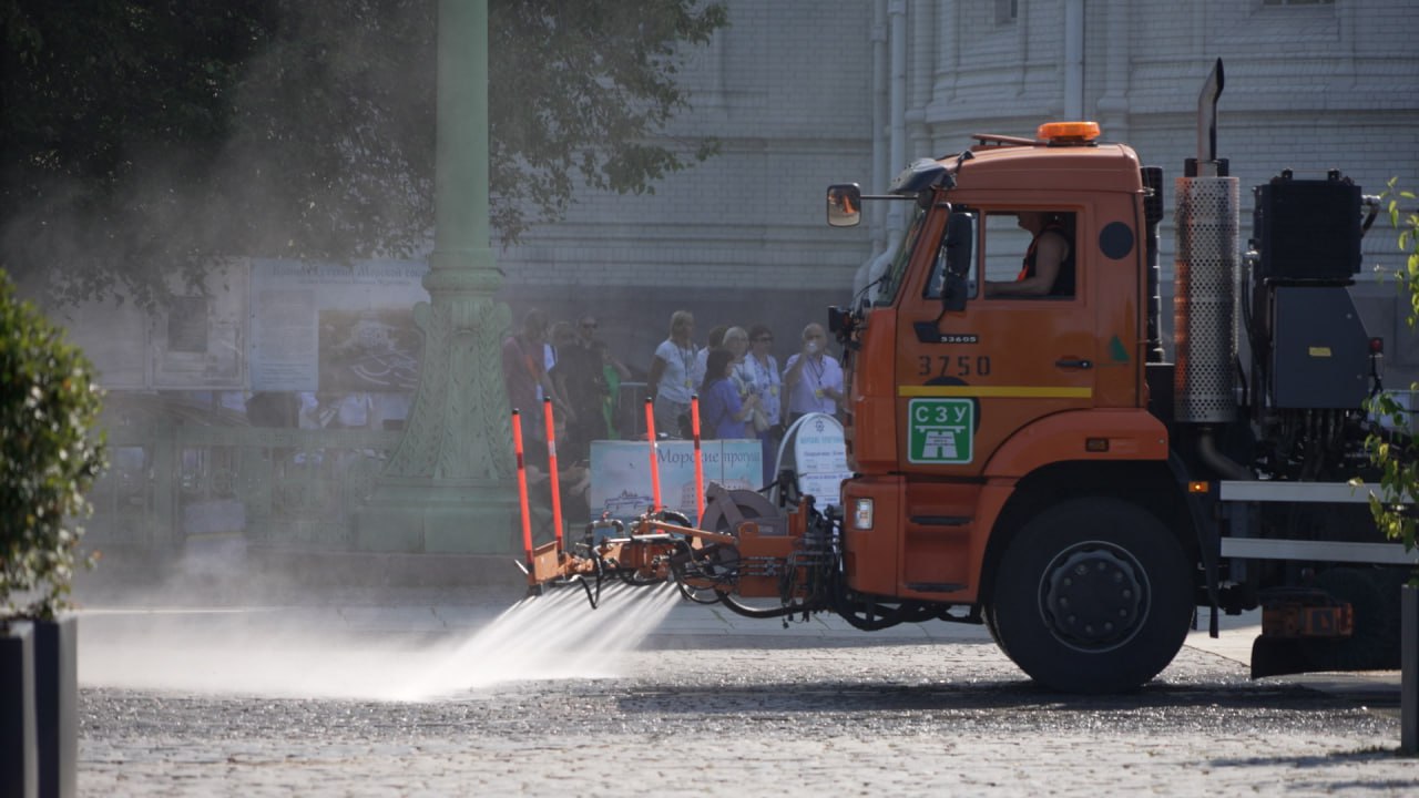 Петербургские дорожники устраивают водные процедуры в раскаленном городе. Поливальная техника стремится к открытым, постоянно прогретым солнцем участкам, площадям, перекресткам больших магистралей, районам с плотной застройкой. Работники охлаждают раскаленный асфальт и плитку, помогая прохожим легче переносить зной. Всего за 7 дней для уборки и орошения города они использовали 61 тыс. кубометров воды. Сегодня городские улицы пылесосят, избавляют от мусора, моют и орошают 529 единиц техники и 926 работников ручного труда. Фото: скриншот с видео/Город+