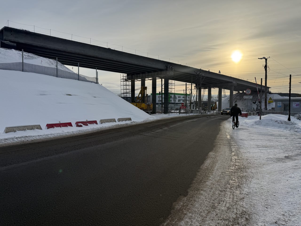 В Новосинеглазово продолжают строить долгожданный путепровод Мост через ж д пути на улице Челябинской в Новосинеглазово планируют завершить к 20 августа нынешнего года Это единственная дорога связывающая поселок с другими районами и объект решит проблему пробок перед переездом Сейчас перенесены инженерные сети построена насыпь и смонтированы балки После потепления подрядчик приступит к мостовому полотну асфальтированию подходов и благоустройству