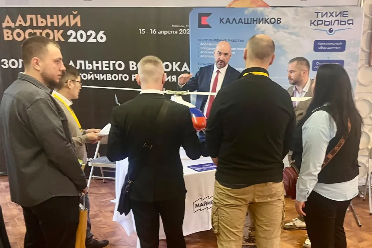 ООО ГК Тихие Крылья концерн Калашников представило оригинальный комплексный подход к сбору и обработке данных с помощью беспилотных летательных аппаратов БЛА о поверхности земли золотодобытчикам Дальнего Востока на Горном форуме и выставке МАЙНЕКС Дальний Восток которая проходит в Магадане 15 16 апреля 2026 года Его основная концепция применение нескольких методов сбора данных с использованием БЛА аэрофотосъемка воздушное лазерное сканирование и аэромагнитная съемка собственная обработка полученной информации и выдача готового результата под ключ Такой подход компании разработчика беспилотников позволяет заказчикам достигать высокой экономической эффективности Основные проблемы с которыми сталкиваются геологоразведочные компании на Дальнем Востоке это высокая капиталоемкость сложная логистика суровый климат и высокие требования по экологии Мы все это хорошо изучили на собственном опыте при выполнении нескольких заказов в регионе в 2024 и 2025 годах отметил коммерческий директор ООО ГК Тихие Крылья Максим Сабадаж Сегодня мы предлагаем региону оптимальное соотношение цена качество Высокая квалификация сотрудников наличие собственного парка беспилотников производственной базы которая при необходимости может быть дополнена широкими возможностями концерна Калашников а также собственного центра обработки данных позволяют нам выполнять заказы в разумные сроки и по приемлемым ценам В зависимости от поставленной задачи и варьируя набором методов компания может уточнить геологическое и структурно тектоническое строения исследуемого участка подготовить высокоточную геодезическую основу повысить точность прогноза для последующего бурения и горных работ оптимизировать объем выполняемых полевых работ создать топографические планы цифровые модели местности и рельефа карты аномального магнитного поля его производных схемы геологической интерпретации комплексных данных с определением локализации перспективных рудоносных зон Для выполнения заказов горнорудных компаний Тихие Крылья как правило применяют разработанные беспилотные летательные аппараты вертолетного типа Альфа Е производительность которых достигает 290 погонных км день что является самым высоким показателем в России для беспилотников данного типа весом до 30 кг При использовании Альфа Е можно проводить высокоточную магнитную съемку с детальным огибанием рельефа на предельно малых высотах в горных регионах и районах со сложно расчлененным рельефом при требуемых масштабах съемки от 1 5 000 до 1 25 000 Компания также применяет БЛА Легионер собственного производства для авиамониторинга протяженных объектов Данный беспилотный летательный аппарат вертикального взлета и посадки предназначен для анализа состояния объектов ТЭК транспортной инфраструктуры ЛЭП градостроительства лесных массивов и сельскохозяйственных угодий эффективен в предотвращении террористических угроз при проведении поисково спасательных операций и оперативно розыскных мероприятий сообщают в пресс службе Концерна В Магаданской области уже используют продукцию концерна Калашников Так во время осмотра экспозиции губернатору региона Сергею Носову помимо БЛА Альфа Е представили и Легионер который выпускается с двумя типами двигателей электрическим и двигателем внутреннего сгорания и может поставлять с разными видами целевых нагрузок Максимальная продолжительность полета БЛА составляет более 5 часов аппарат может использоваться при ветре до 15 м c с массой полезной нагрузки до 4 кг Глава региона отметил актуальность для использования в Магаданской области беспилотника Легионер с двигателем внутреннего сгорания что позволит выполнять задачи в условиях сильных морозов на расстояния свыше 500 км Подпишись на Флай Дрон в MAX Подпишись на Флай Дрон в ВК