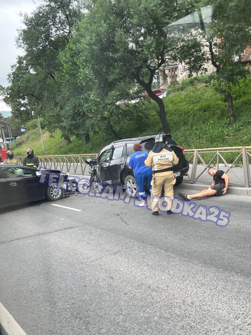 Во Владивостоке на Баляева парализовало дорогу из-за жесткого ДТП — есть пострадавшие  На кадрах видно, как один из пострадавших лежит с травмами, облокотившись на забор. Люди объезжают только через встречную полосу. На месте работают спасатели и медики.    Админу
