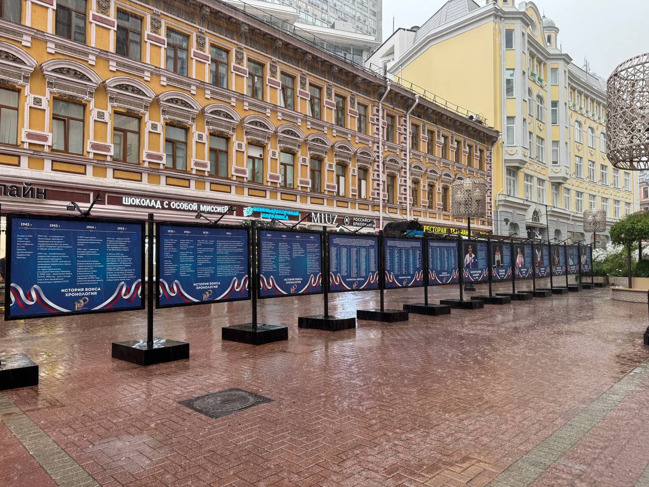 Сегодня на Арбате состоялась церемония открытия выставки фотографий с изображениями легендарных советских и российских боксёров, организованной в честь празднования 130-летия отечественного бокса. Теперь в самом сердце Москвы можно познакомиться с историей нашего вида спорта и фотографиями всех олимпийских чемпионов по боксу в истории СССР и современной России. Также на отдельных стендах перечислены имена и фамилии чемпионов Европы и мира. Одним их почетных гостей был Александр Лебзяк: "Хочу всех поздравить с днём рождения отечественного бокса. Сегодня мы отмечаем 130 лет огромной истории и целых поколений спортсменов. Для нас большая честь продолжать те традиции, которые заложили наши великие чемпионы. Очень рад быть частью нашего вида спорта." Александр Поветкин поделился: "Сегодня мы отмечаем важную дату в истории бокса и мне очень приятно быть частью этой истории. Прекрасная идея организовать выставку фотографий всех олимпийских чемпионов и приятно смотреть, что и моё фото есть в списке легендарных людей, которые проявляли страну на мировой арене." Подробнее про выставку Отдай свой голос боксу!