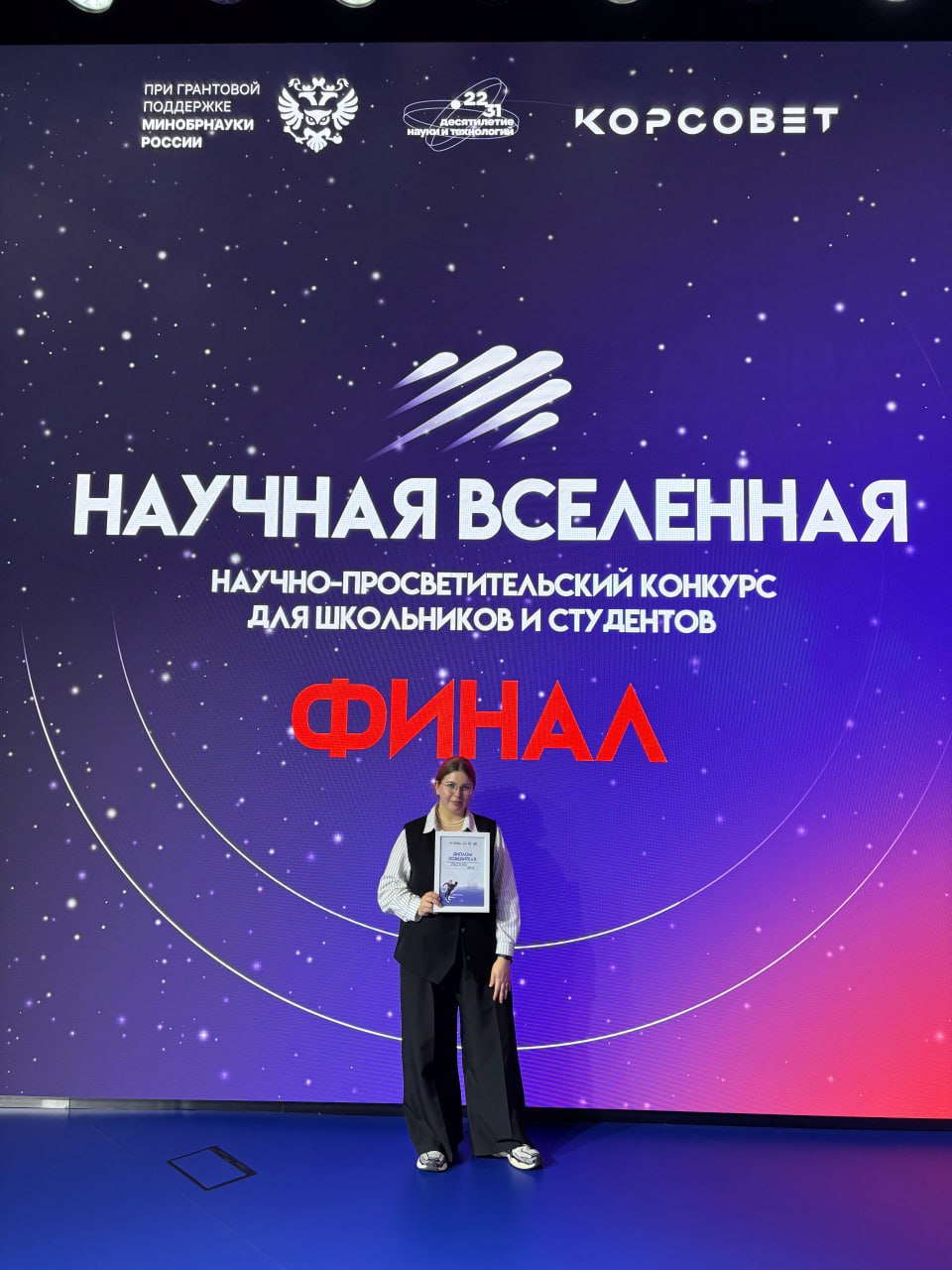 Научная вселенная Яны Русских Аспирант высшей биотехнологической школы Яна Русских победила в конкурсе Научная Вселенная На отборочном этапе требовалось пройти тестирование по тематике выбранного трека На этапе полуфинала нужно было предоставить письменное решение кейса а также подготовить видеовизитку о значимости науки в своей жизни и перспектив Финальный этап заключался в доработке проекта под руководством наставников и его защите перед конкурсным жюри Задачей кейса была разработка стратегии модернизации агропромышленного комплекса с поголовьем 1000 особей направленной на комплексное решение трех ключевых проблем минимизацию выбросов метана и углеродного следа снижение зависимости от импорта кормов и создание новых источников дохода Я предложила проект трансформации предприятия в замкнутую экологическую систему Его основу составили биогазовые установки вертикальные фермы для выращивания кормовых культур и системы мониторинга с применением ИИ Ключевым элементом позволившим замкнуть цикл стала технология получения кормового белка из отходов КРС что напрямую сократило импорт кормов В качестве награды победителей ждет поездка на космодром Восточный в ноябре Конкурс Научная Вселенная реализуется при грантовой поддержке Минобрнауки России в рамках инициативы Наука побеждать Десятилетия науки и технологий