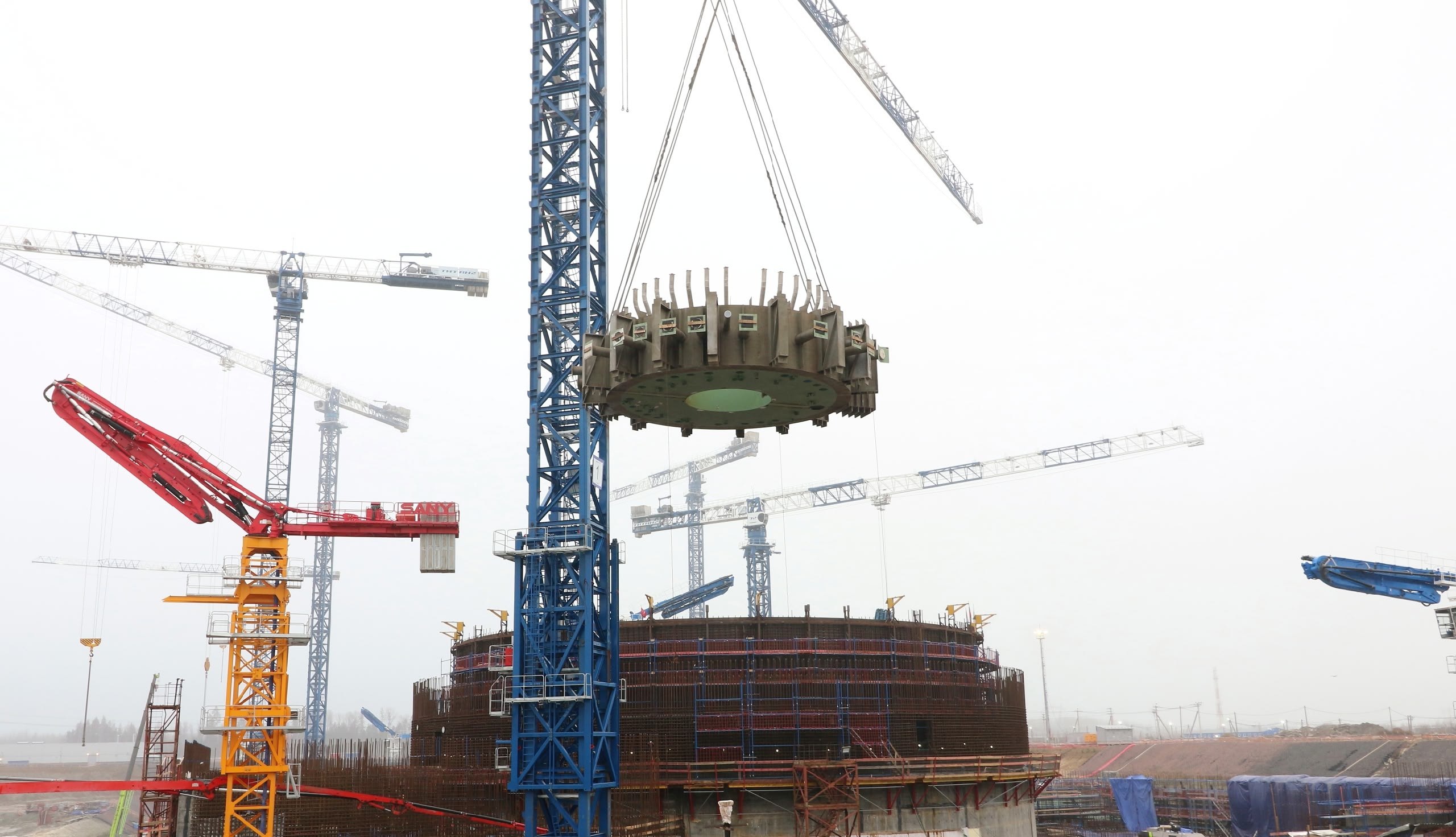 Росатом VK На площадке строящегося энергоблока 3 ВВЭР 1200 смонтировали ферму консоль ловушки расплава ключевого элемента пассивной системы безопасности Конструкцию собрали из двух стальных полуколец укрупнили трубопроводами подачи воды и сброса пара лапами опорами коридором для доступа оперативного персонала и установили на проектное место в шахту реактора поверх корпуса ловушки расплава Установку выполнили специалисты ТИТАН 2 с помощью тяжёлого гусеничного крана Монтаж занял около 12 часов масса конструкции 140 тонн