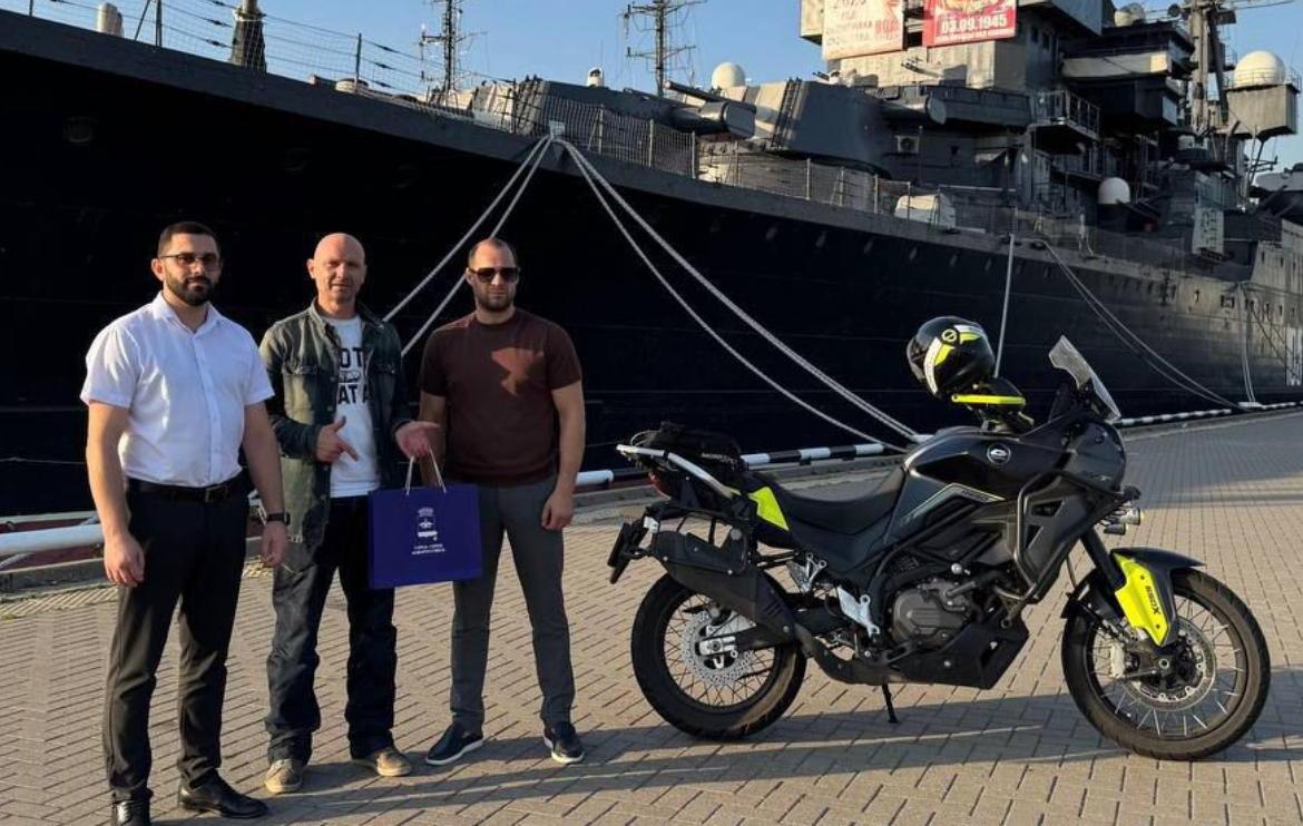 В городе-герое Новороссийске финишировал федеральный патриотический культурно-патриотический мотомаршрут  06 августа в Новороссийске финишировал культурно-патриотический проект федерального масштаба «Белое → Чёрное. Море2». Маршрут протяжённостью свыше 3000 километров стартовал в Архангельске, на берегу Белого моря, и завершился у берегов Черного моря, в городе-герое. Проект символически «соединил» два моря, два полюса России.  Встречу участника мотомаршрута, преодолевшего непростой путь за более чем 40 часов, организовали представители управления внутренней политики и администрации Центрального внутригородского района.  Автор и участник проекта Максим Привезенцев, писатель, режиссер, путешественник, рассказал, что выбор финальной точки маршрута был осознанным и символичным.  «Новороссийск – это не просто Южная гавань страны, но и морская цитадель России, где воинская слава, память и морская мощь сливаются воедино. Финиш на берегу Цемесской бухты стал спортивной отметкой и культурным жестом уважения к истории и силе города-героя», - отметил Максим Вячеславович.  Он также подчеркнул, что мотомаршрут — это не гонка и не шоу, а культурно-философское паломничество, в котором город встречает не рекордсмена, а человека, прошедшего непростой путь. Формат проекта призван развивать новое понимание мототуризма, которое основывается на уважительном отношение к городам и их истории. Новороссийск станет финальным аккордом фильма и книги о путешествии к южной точке страны не только в географическом, но и в смысловом измерении. Символический финиш на набережной подчеркнул значимость Новороссийска как места, где путь с Севера обретает завершение и смысл.