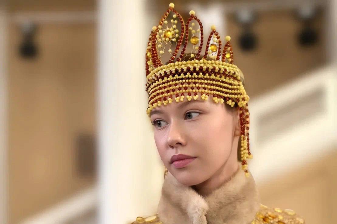 1145 граней янтаря Мастера Калининградского янтарного комбината удивили публику на Международном форуме в Санкт Петербурге Был представлен уникальный кокошник созданный из 1145 элементов балтийского янтаря Возраст камня около 50 миллионов лет а его оттенки варьируются от нежного белого до насыщенного коньячного Вес изделия всего 243 грамма но за этой лёгкостью скрывается кропотливая работа бусины и кабошоны редких цветов были обработаны с использованием современных технологий чтобы подчеркнуть глубину цвета и структуру камня Кокошник сохранил традиционную форму но стал настоящим произведением искусства объединив историю и инновации Вместе с ним мастера представили и другие аксессуары например янтарные обручи для волос которые также вызвали восторг у гостей форума Фото mbn360 dvved