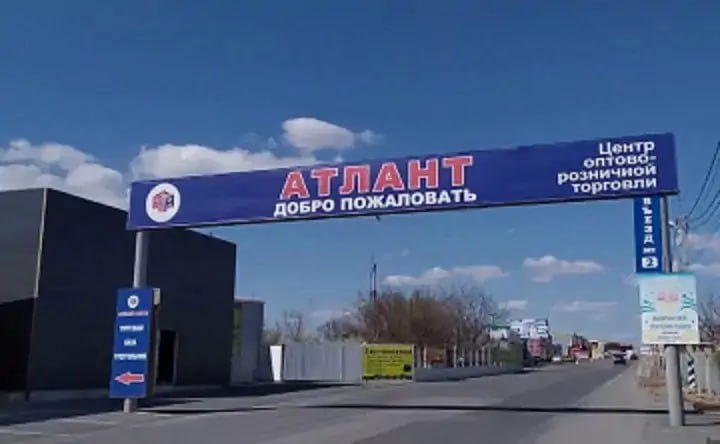 В минстрое объяснили, почему не приступают к застройке бывших аксайских рынков К застройке бывших аксайских рынков — «Атланта», «Овощного», «Строительного» и «Алмаза» — пока приступить невозможно, сообщил изданию domostroydon замминистра строительства Ростовской области Глеб Мельников. Это связано с тем, что некоторые земельные участки остаются под обременениями из-за уголовных дел так называемой аксайской ОПГ. Напомним, что по делу проходят известный бизнесмен Карим Бабаев, бывший глава администрации Аксайского района Виталий Борзенко, экс-директор рынка «Атлант» Александр Карпенко и другие люди. Следствие считает, что земли под бывшими рынками были получены незаконно. Для этого члены ОПГ использовали ряд схем. В частности, обменивали земельные участки из фонда распределения Аксайского района на другие, принадлежащие Бабаеву. В 2024 году стало известно, что участки бывших рынков общей площадью около 116 гектаров рассматриваются властями как перспективная зона для масштабного градостроительного проекта. Тогдашний министр строительства Ростовской области Юрий Сильвестров сообщал, что здесь планируется создать единую концепцию северного въезда в Ростов. Часть участков возвращены в собственность Аксайского района, но по другим пока идут судебные слушания. Из 69 участков 32 до сих пор находятся под арестом в связи с расследованием уголовных дел. Пока территория пустует, и на отдельных участках уже появились стихийные свалки. В муниципалитете поясняют, что не могут их убрать, так как участки не оформлены в муниципальную собственность. Подписаться на "Новости Ростова" Прислать новость