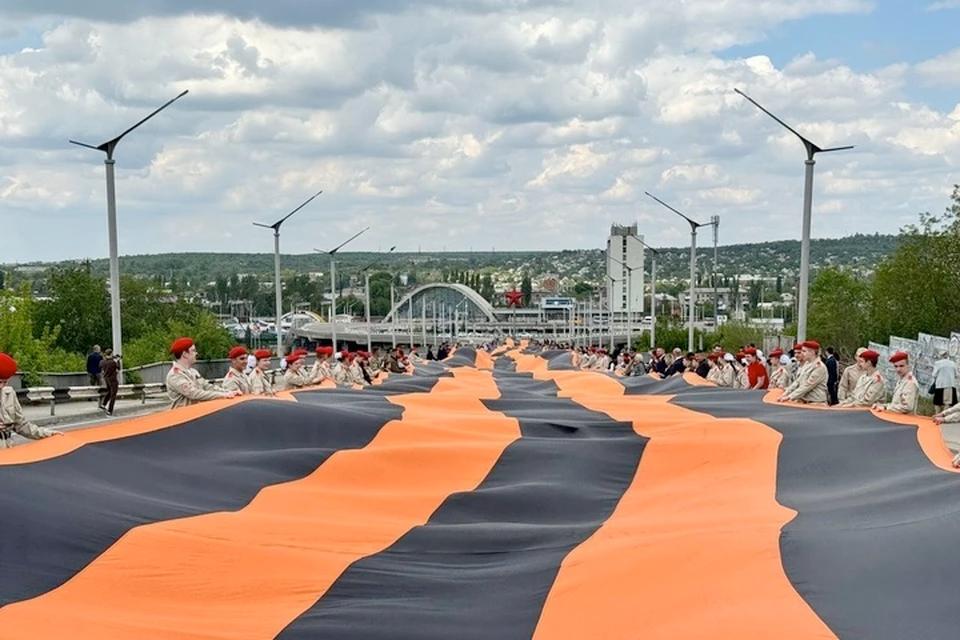 Символ единства народа: В Луганске 400 человек развернули 300-метровую георгиевскую ленту В День Луганской Народной Республики в Луганске развернули 300-метровую георгиевскую ленту. Лента стала одним из символов Русской весны результатом которой стало проведение референдума и провозглашение Луганской Народной Республики. Огромное полотно растянули 400 человек от эстакады железнодорожного вокзала до улицы Коцюбинского.