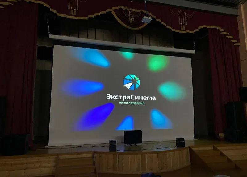 Первый кинозал по нацпроекту Семья открылся в якутском поселке Усть Мая В посёлке Усть Мая состоялось торжественное открытие первого кинозала по национальному проекту Семья реализуемому по инициативе Президента страны Владимира Путина Система Экстра Синема кинопроектор системы контроля посещаемости моторизированный экран акустическое оборудование установлена в местном центре культуры Специалисты компании провели настройку и тестирование оборудования а также инструктаж и обучение сотрудников клуба сообщила пресс служба компании Мы открываем современный кинозал благодаря нацпроекту Семья и компании Экстра Синема Теперь мы можем предложить нашим жителям возможность для комфортного и увлекательного отдыха Здесь вы увидите премьеры отечественных и мировых фильмов насладитесь любимыми мультфильмами вместе с детьми и проведете незабываемые вечера в кругу друзей и близких сказала директор Усть Майского культурного центра народного творчества Надежда Саввина Генеральный директор компании Экстра Синема Петр Чиряев сообщил что компания стала первой в стране предложившей защищённую технологию цифрового кинопоказа адаптированную под условия малых городов В отличие от классических проекторов система полностью исключает несанкционированное копирование и гарантирует соблюдение авторских прав добавил он На открытии жителей посёлка поприветствовали глава Усть Майского района Александр Азаров представители управления культуры кинематографисты и представители общественности На торжественном открытии кинозала в фойе местного дома культуры прошла выставка посвящённая истории кино в районе Демонстрация фильмов в районе началась в 1966 году в посёлках Усть Мая Эльдикан Аллах Юнь и в селе Петропавловск С 1988 года из Якутска стали доставлять фильмы раз в месяц самолетом Добрыми словами вспомнили специалистов которые работали в киноклубах района Валентину Федорову Ольгу Андреняк Анатолия Федорова Николая Винокурова Агафью Докторову Людмилу Винокурову Евгению Елизарьеву Ивана Иванова Юрия Елизарьева Аркадия Акимова Александру Судинову Михаила Иванова Руслана Кириллина Юрия Таюрского Владимира Перевалова Тамару Верхотурову Вячеслава Федорова Феклу Амбросьеву Владимира Назаренко Розалию Татарченко Агафью Апросимову Дмитрия Догоюсова Александра Зажирского По заявке жителей первым фильмом который показали в кинозале стала кинокартина Диодорова Против течения собравшая в прокате более 48 5 млн рублей Создаваемые залы Экстра синема подключены к единой цифровой платформе содержащей лицензионную библиотеку российских фильмов мультфильмов и просветительских программ Контент подбирается с учётом зрительских предпочтений а все просмотры прозрачны для правообладателей Усть Майский центр культуры стал участником программы кинофикации сельских и малых территорий которая разработана с учётом опыта компании Экстра Синема и реализуется по поручению Президента страны Владимира Путина в рамках национального проекта Семья для обеспечения доступа граждан РФ к достижениям современного российского кинематографа В 2025 году получателями финансовой поддержки стал 41 малый населённый пункт из 21 региона страны сахасирэ ольгабалабкина мыработаем якутия арктика экология арктическаяякутия Подписывайтесь на канал   t me balabkinaov