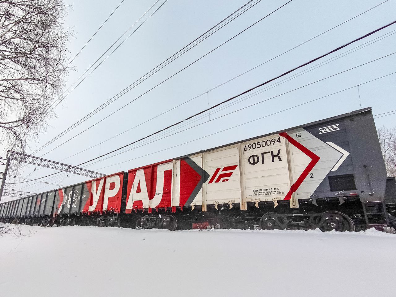 Урал отправился на Дальний Восток первый состав с новыми полувагонами повысит провозную способность Транссиба и БАМа Первый в России поезд из новейших восьмиосных полувагонов Урал отправили с станции Линёво в Новосибирской области в Приморский край на станцию Смоляниново Состав гружён углём и идет на Дальний Восток по программе усиления пропускной способности Восточного полигона Урал инновационный полувагон модели 12 5991 без аналогов в России грузоподъёмность 151 тонна объём кузова 176 куб м срок службы 32 года   Вагон разработан для массовых неагрессивных грузов на магистралях колеи 1 520 мм и рассчитан на эксплуатацию в диапазоне температур от 60 C до 50 C Полувагоны можно обслуживать и ремонтировать на уже существующей инфраструктуре депо и ремонтных баз   Благодаря новому более компактному сцепному устройству сокращается длина каждого вагона в одном поезде можно собрать больше вагонов растёт общая масса поезда и эффективность перевозок Первая партия из 40 Уралов передана Уралвагонзаводом УВЗ Федеральной грузовой компании ФГК по контракту подписанному на салоне PRO Движение ЭКСПО в Санкт Петербурге летом 2025 года В УВЗ подчёркивают предприятие готово выпускать столько вагонов сколько потребуется заказчику ФГК планирует тиражировать технологию восьмиосного подвижного состава по всей сети РЖД В перспективе масса поезда из полувагонов Урал при стандартной длине в 71 условный вагон может достигать 8 000 тонн Восточный полигон это Транссиб БАМ которые уже работают на пределе Идёт масштабная модернизация в 2024 году по поручению президента была поставлена задача ещё увеличить объём перевозок Однако как отмечал вице премьер Юрий Трутнев в декабре 2025 года полигон всё ещё не справляется с необходимыми объёмами Новые тяжёлые составы вроде Уралов один из инструментов чтобы это изменить Дальневосточная магистраль спад сырьевых грузов рост руд и агроэкспорта Главное про Дальний Восток