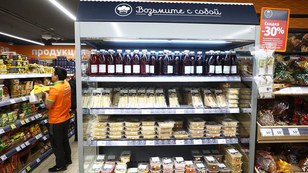 Оборот готовой еды вырос на треть за январь сентябрь 2025 года такие данные приводят Ассоциация производителей и поставщиков готовой еды АППГЕ и аналитическая компания NTech пишет Коммерсант В натуральном выражении сегмент вырос на 17 год к году За этот период высоким спросом пользовались готовые горячие напитки заказы которых увеличились на 108 год к году суши и роллы рост на 81 бутерброды и сэндвичи на 51 готовая пицца на 46 и каши на 43 Ёмкость всего рынка готовой еды по итогам 2025 года оценивают в 1 14 трлн рублей на 20 больше чем в 2024 м В АКОРТ отмечают что по оценкам участников рынка в ближайший год сегмент готовой еды продолжит опережать средние темпы роста продуктовой розницы Однако в сегменте готовой еды есть ряд аспектов которые могут притормозить его развитие Прежде всего это нехватка поставщиков в регионах Дальнего Востока в то время как в крупных городах в центральной части России таких проблем не наблюдается поясняет президент АППГЕ Сергей Беляков По его словам нехватка поставщиков наблюдается из за нехватки техники и фабрик кухонь и отсутствия крупных производителей особенно в отдаленных регионах подчеркивает господин Беляков При этом для сетей с собственным производством и крупных поставщиков доставка готовой еды на Дальний Восток нерентабельна из за высоких затрат на логистику коротких сроков годности продукции и необходимости соблюдать особые условия ее хранения