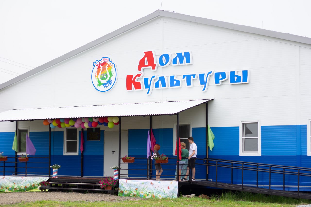 Первый модульный дом культуры заработал в Еврейской автономной области Долгожданное открытие дома культуры состоялось в селе Партизанское, Смидовичского района ЕАО. От имени врио губернатора области Марии Костюк жителей поздравил и.о. заместителя председателя правительства ЕАО Валерий Жуков: «Благодаря совместным усилиям, мы получили прекрасный объект, в котором молодое поколение будет воспитываться и получать новые знания, а старшее – передавать накопленный опыт. С праздником!» С приветственным словом выступил глава Смидовичского района Евгений Башкиров: «Обычно дома культуры – это места притяжения. У вас есть замечательная история и замечательные творческие коллективы. Люди сюда будут тянуться. Пользуйтесь, наслаждайтесь, самое главное, приводите сюда детей, оставайтесь здесь! Мы всегда работаем на благо вас, наших жителей». В новом здании оформлены несколько функциональных зон: библиотека, гримерная, зрительный зал, творческая студия и методический кабинет. Всё это будет постепенно обустраиваться, в зал уже закупили проектор 4К-разрешения и планируют показывать кино. Евгений Башкиров вручил главе Волочаевского сельского поселения Людмиле Марцевой денежный сертификат на дальнейшее благоустройство дома культуры внутри. Также, дополнительно, по поручению врио губернатора ЕАО Марии Костюк, выделено 10 миллионов рублей на благоустройство территории вокруг нового здания. «Это непередаваемые ощущения, конечно. Мы очень рады, что наконец-то открыли двери нашим новым и старым участникам клубных формирований. Жизнь будет кипеть в этом ДК, это точно!», – делится эмоциями директор дома культуры Олеся Вырупаева. Модульный ДК возведен в Партизанском в рамках государственной программы «Комплексное развитие сельских территорий». Прежний дом культуры в селе считался аварийным, в 2023 году его снесли. Возведение первого в регионе модульного ДК вместимостью до 50 посадочных мест было закончено в 2024 году. Здание построено в один этаж площадью более 400 квадратных метров, и оборудовано системами отопления и водоснабжения. Стоимость нового объекта составила более 33,2 млн. рублей.