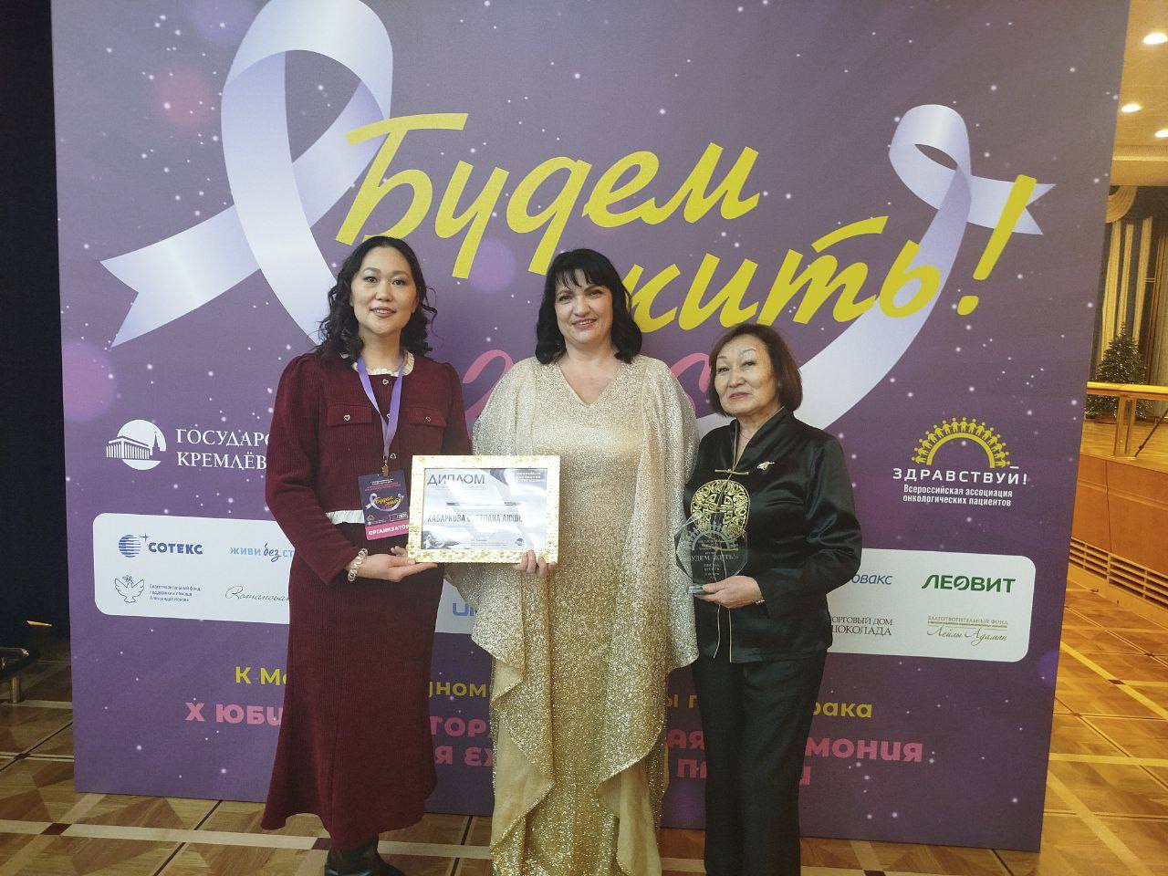 Светлана Хабаркова стала лауреатом ежегодной всероссийской премии Будем жить Организация онкопациентов Я живу из Бурятии работающая с 2015 года отмечена за системную ежедневную работу по защите прав онкобольных юридическую поддержку в получении лекарств и квот психологическую помощь сопровождение на всех этапах лечения и создание сообщества взаимопомощи Эта награда не личная Она принадлежит каждому кто 11 лет был частью нашего общего дела коллегам отвечающим на ночные звонки юристам добивающимся жизненно важных препаратов волонтерам и прежде всего нашим пациентам тем кто прошел этот путь и теперь поддерживает других Руководитель организации Я живу Марина Захарова победившая рак 4 й стадии стала живым примером надежды и стойкости рассказала член ОП РФ Мы начинали в 2015 году чтобы закрыть ту страшную пустоту которую чувствует человек после диагноза одиночество непонимание бесправие Мы стали мостиком от отчаяния к надежде от вопроса почему я к вопросу что делать Эта награда подтверждение что путь верен Эта стела не точка а многоточие Пока есть те кому страшно и одиноко после диагноза наша миссия не закончена Мы и дальше будем дарить надежду Будем жить и помогать жить другим Рука об руку Общественная палата России Телеграм МАХ ВКонтакте