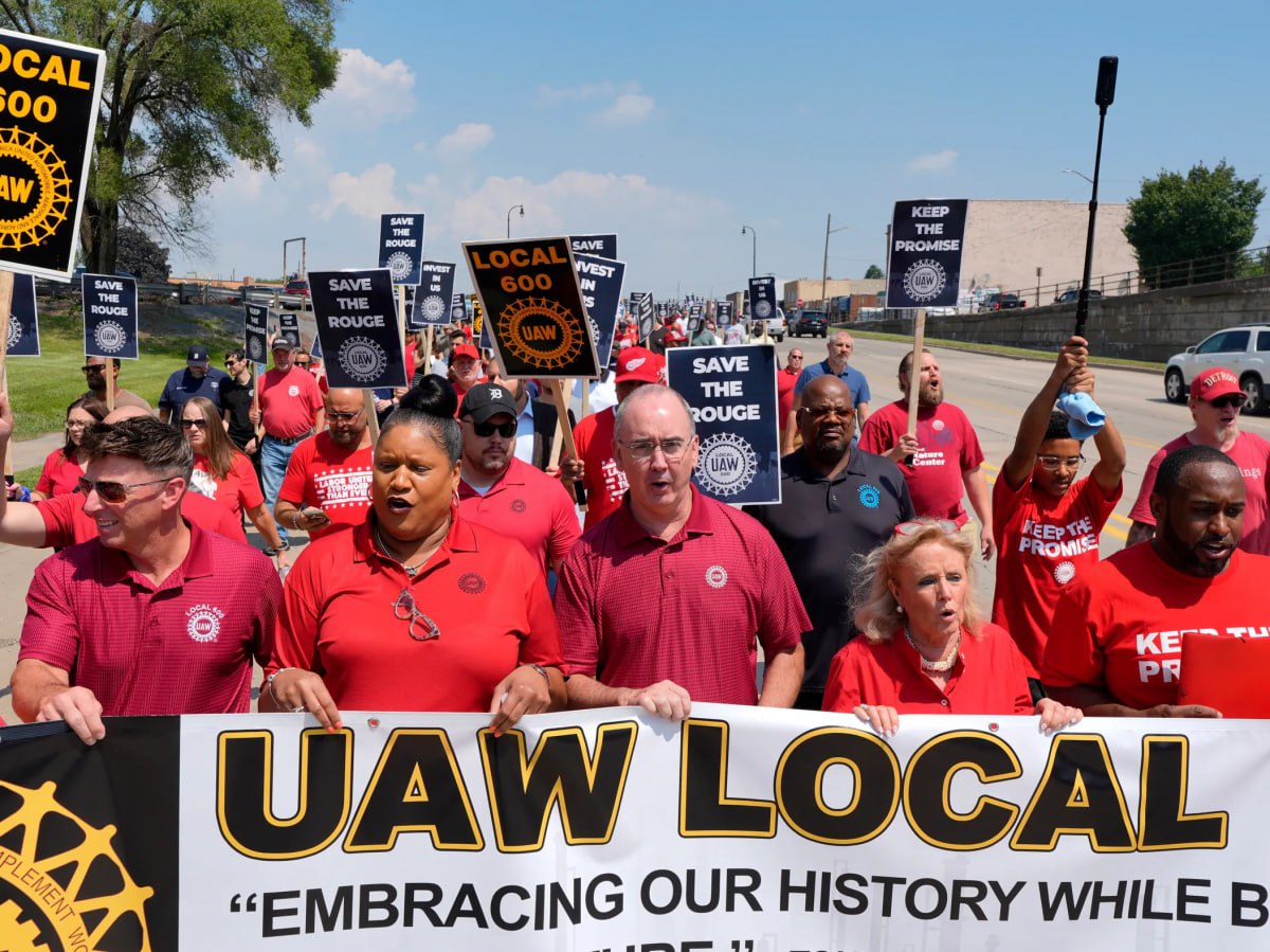 Американский и немецкий автопром лихорадит На США надвигается волна увольнений На этот раз под удар попала автоиндустрия Лидер отрасли корпорация Дженерал моторс планирует сократить свыше 1700 человек на заводах по производству электромобилей и аккумуляторов в штатах Мичиган Огайо и Теннесси Причём ещё около 1600 специалистов временно отстранят от работы Данное решение эффективные управленцы обосновывают отменой федеральных налоговых льгот и прогнозируемым падением спроса на продукцию Отметим что Дженерал моторс второй крупный игрок на американском рынке электромобилей уступающий лишь Тесле Илона Маска К примеру за 2024 год компания продала более 100 тыс электрокаров Однако реалии капиталистического мира неумолимы финансовое благополучие напрямую зависит от курса политики правительства в Вашингтоне Решение президента Дональда Трампа полностью свернуть программу предшественника Джо Байдена включая отказ от поддержки производителей электрокаров и отмену государственной субсидии в 7500 долларов на покупку или аренду подобных машин поставило под угрозу доходы собственников и интересы потребителей В итоге корректировка бизнес стратегии обошлась акционерам убытками в 1 6 млрд долларов Бремя издержек ожидаемо легло на плечи сотрудников Так завод Фэктори Зеро в Детройте приостановил работу до января 2026 года в связи с чем на улицу вышвырнули примерно треть персонала До середины следующего года также будут простаивать производственные площадки в городах Уоррен и Спринг Хилл Из за замедления темпов внедрения электромобилей в ближайшей перспективе и меняющейся нормативной базы мы перераспределяем мощности по производству Но несмотря на эти изменения Дженерал моторс сохраняет приверженность своему производственному рынку в США подчеркнули представители корпорации Напомним что нынешние кадровые перестановки не единичный инцидент Недавно в рамках реструктуризации автопроизводитель уже уволил 200 инженеров Между тем напряжение нарастает на единственном сборочном заводе Фольксваген в США Коллектив предприятия в Чаттануге штат Теннесси при содействии Объединённого профсоюза рабочих автомобильной промышленности UAW большинством голосов высказался за проведение забастовки Пролетарии добиваются справедливого коллективного контракта а также обвиняют немецкого автогиганта в практике недобросовестных переговоров и запугивании Дата предстоящих протестов которые затронут 3 тысячи сотрудников пока неизвестна В ходе многомесячных обсуждений работодатели предложили повышение жалованья на 20 к 2029 году а также различные премии и поощрения Тем не менее члены UAW настаивают на 25 Как утверждают разгневанные активисты в 2024 году компания получила прибыль в размере 20 млрд долларов что позволяет обеспечить более высокую оплату Кроме того персонал недоволен отсутствием в контракте пункта о защите рабочих мест В сущности профсоюз стремится к тому чтобы будущий договор отражал условия действующие на предприятиях Большой детройтской тройки концернов Стелантис Дженерал моторс и Форд Я голосую за стачку поскольку сейчас подходящее время показать Фольксваген что мы настроены серьёзно Гарантии занятости это самое важное Они могли бы платить нам 100 долларов в час но это ничего не значит если они закроют завод через две недели после заключения соглашения Мы покажем им что их предложение было недостаточным покажем им что мы готовы бороться за то чего заслуживаем прокомментировал ситуацию один из работников Как ранее сообщала Правда немецкий автопроизводитель находится в кризисе основной причиной которого стала тарифная политика США Согласно прогнозам 15 процентные пошлины на экспорт автомобилей обойдутся компании в несколько миллиардов евро ежегодно Так третий квартал 2025 года Фольксваген завершил с убытками в 1 07 млрд евро Иван ПЛОТНИКОВ