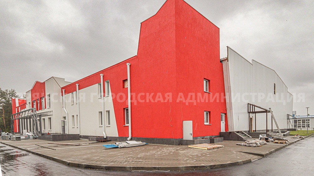 В Брянске завершается строительство Дворца зимних видов спорта. В Фокинском районе. В областном центре он станет 4-м по счету круглогодичным учреждением с ледовой ареной. Сооружение окрашено в красно-белый. Открытия ждут и взрослые, и дети. Специалисты благоустроили прилегающую территорию: уложили тротуарную плитку, асфальт, выполнили подсыпку грунта, смонтировали водосточные системы. В помещениях установили окна и двери. На объекте трудятся электрики, вентиляционщики, слаботочники, маляры, отделочники. На следующей неделе на объект «приезжают» борта ледовой арены, которые строители тут же начнут монтировать. Совсем скоро подрядчики доставят ограждения и сидения для трибун. На большой ледовой стройке трудятся в день от 20 человек — всё зависит от объёма поставленных задач. Дворец зимних видов спорта находится в микрорайоне «Орловский». Его возвели в рамках федерального проекта «Спорт — норма жизни» нацпроекта «Демография». Фото: пресс-служба Брянской горадминистрации.