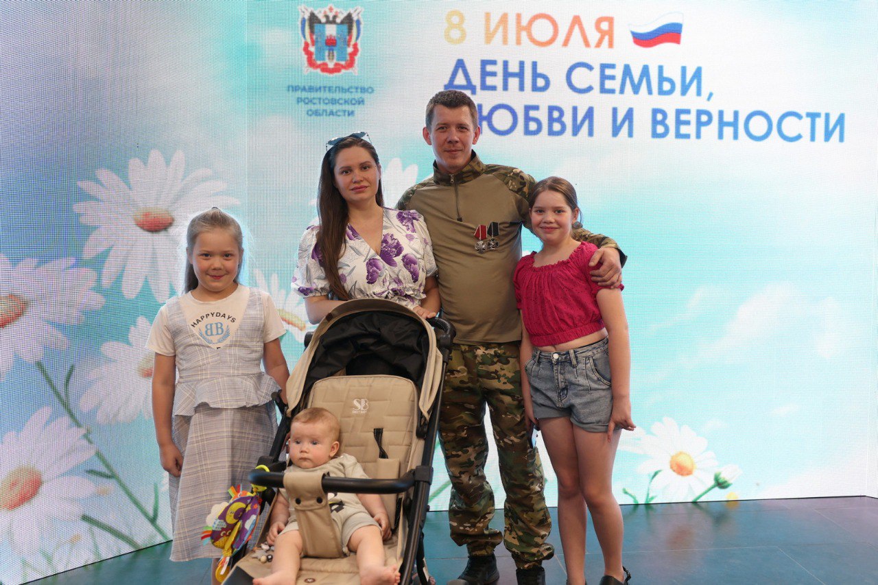 Юрий Слюсарь рассказал о поддержке молодых семей на Дону в 2026 году: от выплат в 100 тысяч рублей до запуска «цифровых помощников» В День семьи, любви и верности врио губернатора Ростовской области Юрий Слюсарь встретился с супружескими парами и анонсировал новые меры поддержки для семей. Их планируют ввести в следующем году. Так, с 2026 года семьи, где будущая мама встала на учёт по беременности на ранних сроках, смогут получить единовременную выплату в 100 тысяч рублей. Для малообеспеченных родителей может появиться услуга «Социальная няня», кроме того, специалисты разработают специального чат-бота, который поможет разобраться в действующих мерах господдержки. В ходе неформальной встречи за чашкой чая участники предложили учредить в регионе медаль для поощрения отцов. Юрий Слюсарь поддержал эту инициативу. В этот же день, 8 июля, врио губернатора побывал на торжественном приёме, посвящённом Дню семьи, любви и верности. Он вручил госнаграды, почётные знаки, медали и награды молодым семейным парам.