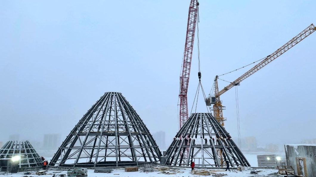 На крыше Арктического центра установили три урасы    Рабочие смонтировали металлический каркас третьей урасы на крыше строящегося здания Арктического центра эпоса и искусств.   Теперь установлены все массивные конструкции общим весом в 140 тонн, включая три урасы и светопрозрачный купол в виде озера.