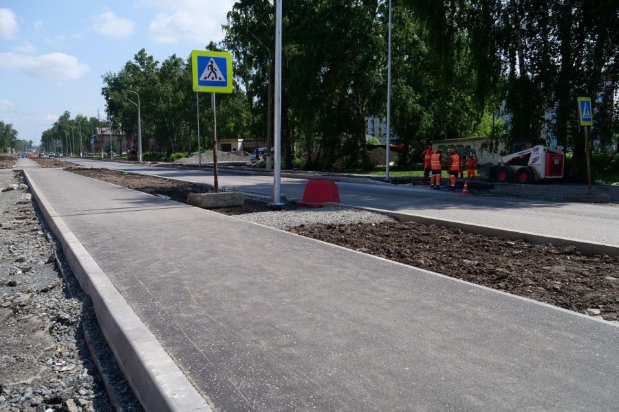 На улице Инициативной в Кировском районе Кемерова продолжается капитальный ремонт Протяженность объекта составляет 2,3 километра. Сейчас подрядчик работает параллельно на нескольких участках улицы, всего задействованы восемь звеньев. Практически завершена вся работа по переустройству инженерных коммуникаций, остался важный этап переврезки водопроводных и канализационных сетей. Сейчас идет строительство пешеходных тротуаров, они будут располагаться по обеим сторонам улицы. На проезжей части почти по всей улице уложены нижние слои асфальта, почти полностью установлен бордюрный камень. Специалисты приступили к вертикальной планировке газонов. Частично смонтировали новое освещение.