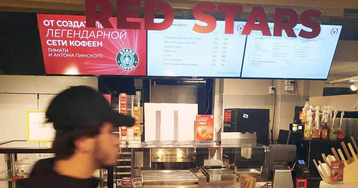 Магнит открыл кофейню Red Stars с Тимати и ресторатором Пинским Первая тестовая точка заработала на Ангарской улице в Москве пока небольшая с плакатами Тимати и Антоном Пинским уже владеющими совместным брендом Stars Coffee В Магните совместные капучино и латте будут продаваться по 129 руб за маленькую порцию Участники франшизы заявили не только о кофе по лучшей цене но и о взаимной выгоде Тимати и Пинский благодаря Магниту расширят масштаб своего бренда а супермаркет сможет догнать Пятерочку у которой открыто уже 18 тыс кофе пойнтов против 7 тыс у Магнита Фото forbes ru