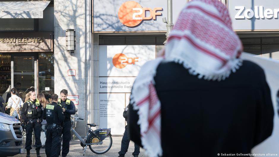 Пропалестинские демонстранты провели акцию в главном офисе телеканала ZDF в Берлине 12 активистов проникнув в вестибюль офиса начали выкрикивать тематические лозунги сообщили в полиции Как отмечает издание Focus демонстранты с помощью гелиевых шаров подняли под потолок здания громкоговоритель из которого раздавались детские крики Вызванные сотрудники полиции через несколько минут вывели активистов из здания но акция затем продолжилась у входа в офис В отношении 12 человек начаты расследования по подозрению в незаконном проникновении в помещение и в нарушении закона о собраниях dwglavnoe