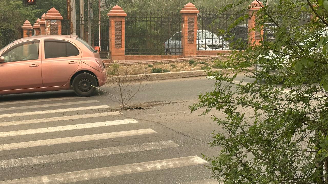 Проезд по полосе дороги в центре Читы ограничен из-за провала в асфальте Жители Читы жалуются на образовавшийся на дороге в центре города провал асфальта. Из-за ямы автомобили не могут проехать по левой полосе. Провал возник на пересечении улиц Петровской и Полины Осипенко, в яму вставили ветку от дерева. "Асфальт провалился прямо на середине дороги, из-за дыры теперь прямо у светофора перекрыт проезд по левой полосе. "Для безопасности" в неё затолкали веточку и всё, яма ничем не огорожена совершенно, не знаю, как водителям, но вот пешеходом я не сразу заметила её и чуть второпях не упала туда, потому что находится она прямо у края пешеходного перехода", — сказала жительница Читы. В пресс-службе администрации города на вопрос корреспондента ИА ChitaMedia ответили, что ранее эта яма уже подсыпалась, в ближайшее время там ещё раз проведут работы по подсыпке. Фото: очевидца ChitaMedia Забайкальский край