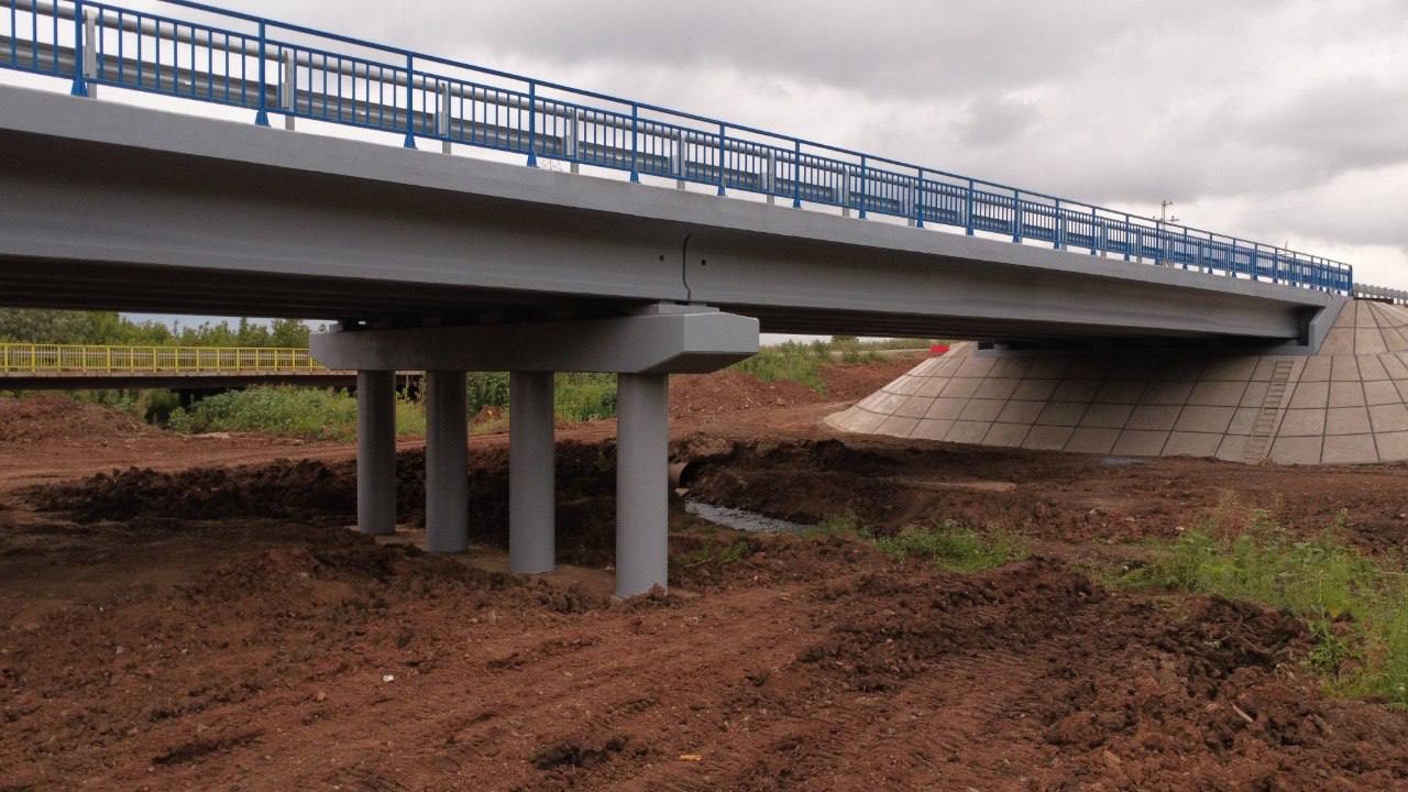 В Переволоцком районе открыто движение по мосту через р. Гусиху Мост находится на 45 км автомобильной дороги Переволоцкий – Кичкасс. Основные работы по капитальному ремонту, который проводится в рамках национального проекта «Инфраструктура для жизни», выполнены – готовность объекта превышает 90 %. Это позволило возобновить движение транспорта, переключив его со временного объезда. Длина сооружения составляет более 62 метров, оно обеспечивает движение транспорта максимальной массой до 100 тонн по одной полосе в каждую сторону. Срок службы моста, как и всех подобных новых железобетонных сооружений, составляет минимум 50 лет. Старый мост, построенный еще в 1980 году, полностью демонтирован. Заменены опоры и пролетные строения. Уложено новое мостовое полотно, покрытие проезжей части из асфальтобетона. Ширина проезжей части увеличена до 10 метров. Ремонтные работы в этом сезоне уже завершены на мостах через р. Мал. Юшатырь на дороге Стретинка – Благодарное в Тюльганском районе и через р. Чаган на дороге Бугульма – Уральск в Первомайском районе – эти объекты также приведены к нормативу по нацпроекту «Инфраструктура для жизни». Ранее в Переволоцком районе было открыто движение по мосту через р. Большой Уран на дороге Кичкасс – Габдрафиково. Всего в этом году в Оренбургской области планируется привести к нормативу 15 мостов и путепроводов, расположенных на дорогах регионального и межмуниципального значения.
