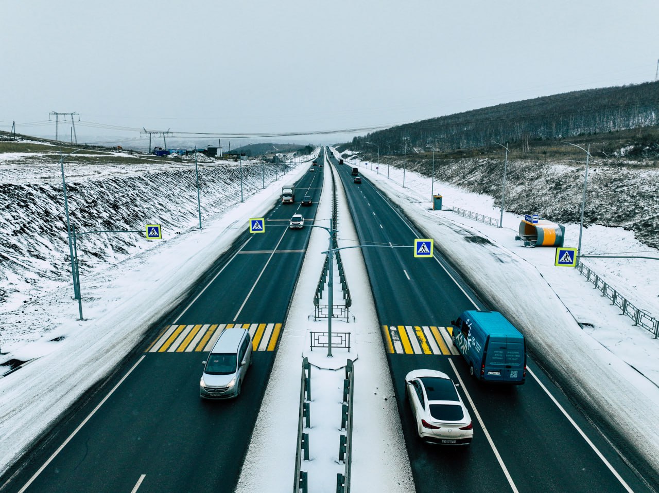 Завершен ремонт обхода Красноярска Рабочие привели в порядок участок от Дрокинской горы до путепровода через проспект Котельникова Там уложили три слоя асфальта смонтировали освещение и водоотвод поставили новые автобусные остановки В 2026 2027 годах в планах реконструкция путепровода через проспект Котельникова на шестом километре обхода Красноярска Его расширят с 21 до 29 метров обновят покрытие построят подземный пешеходный переход из поселка Новалэнд в Солонцы и торговый центр Метро К работам уже приступили там переносят ЛЭП и убрали АЗС Фото КрУДор