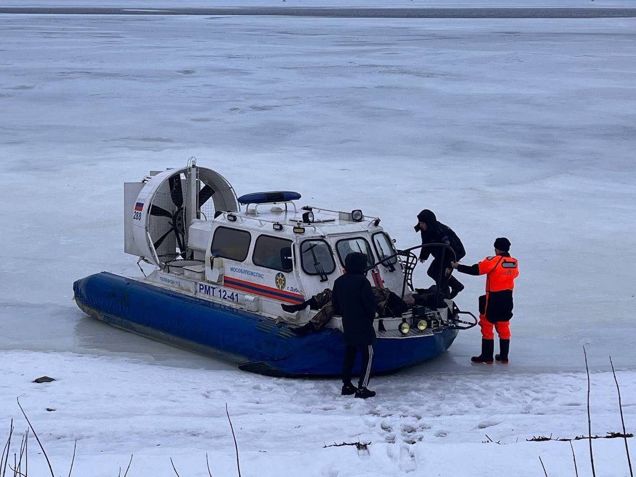 UPD: Мособлпожспас сообщает подробности фатальной драмы на льду в Дубне и публикует кадры с места ЧП:   «Уже возвращаясь домой, буквально в 20 метрах от берега, лед под ногами мужчин провалился, и оба оказались в ледяной воде. Очевидцы происшествия, позвонили в службу 112, и по указанным координатам на судне на воздушной подушке выдвинулись спасатели 215-й пожарно-спасательной части Мособлпожспас.   Прибыв на место, работники дежурной смены обнаружили, что одному из рыбаков удалось выбраться на тонкий лед из полыньи. С признаками переохлаждения спасатели передали 28-летний мужчину медикам скорой помощи для госпитализации. Второй рыбак не подавал признаков жизни. Подняв мужчину на борт, спасатели провели необходимые реанимационные мероприятия, но, к сожалению, безуспешно».