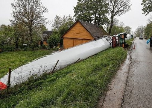 Во двор литовского дома упала лопасть ветрогенератора В Шяуляйском районе Литвы лопасть ветряного генератора, перевозимая на прицепе, упала и угодила во двор частного дома. Крупногабаритный груз — одна из лопастей ветряка — перевозился в сопровождении конвоя, однако по неустановленной пока причине прицеп с тяжеловесной конструкцией перевернулся. Огромный элемент турбины скатился с обочины и повредил дом, находящийся рядом с дорогой. Жителю дома понадобилась медицинская помощь — мужчина не получил физических травм, но испытал сильный стресс. В последнее время в странах Балтии часто обсуждают опасности ветропарков, но такого никто не ожидал.