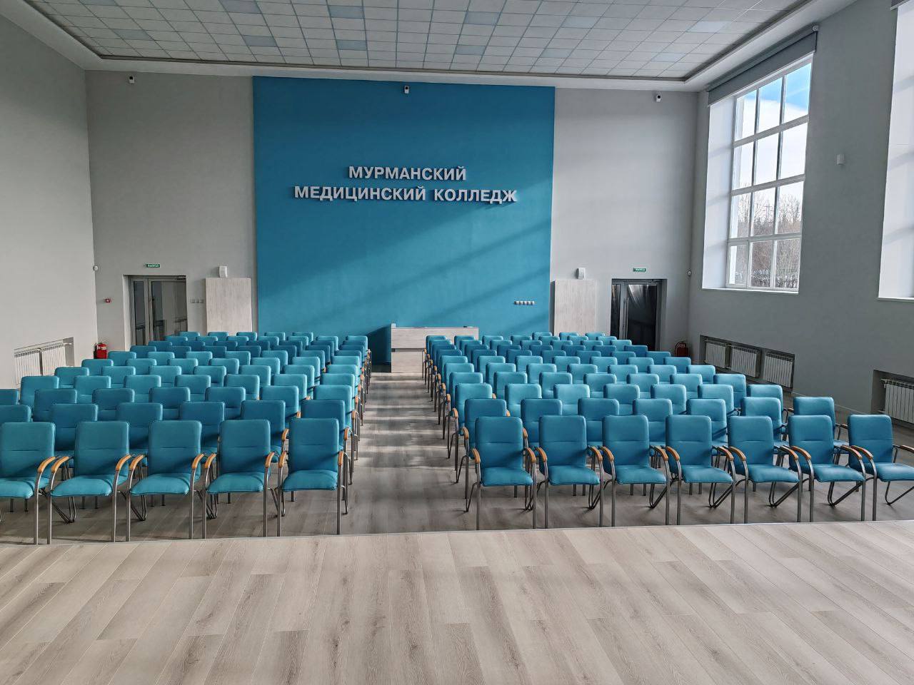 В Мурманском медицинском колледже по поручению губернатора обновили актовый зал  В помещении полностью заменили оконные блоки, электропроводку, напольное покрытие, обновили стены и потолок, закупили новую мебель и современное оборудование. В новом зале колледжа будут проводить лекции, семинары, конференции, художественные и культурные мероприятия. На капремонт из областного бюджета направлено более 16 млн рублей.   Улучшение условий для обучения и проживания студентов СПО – один из приоритетов плана «На Севере – жить!». В 2026 году работы по обновлению ММК продолжатся в рамках президентской программы капитального ремонта.