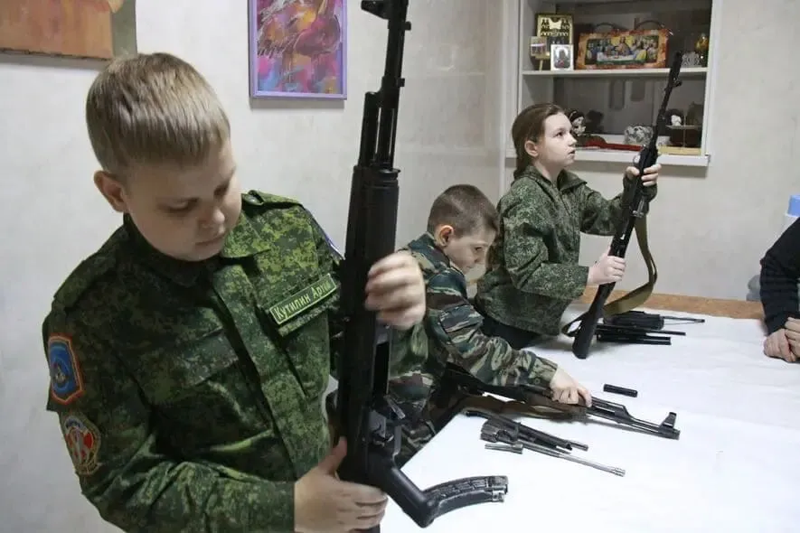Начальную военную подготовку в России хотят сделать самостоятельным предметом Представители Минобороны Минпросвещения и эксперты обсудили параметры возрождаемого курса НВП проект готовится к внедрению в российские школы Предлагается выделить на НВП 64 часа в год это почти вдвое больше чем сейчас отводится на предмет Основы безопасности и защиты Родины ОБЗР 34 часа Курс рассчитан на 9 11 классы школ колледжи Пилотный запуск в ряде регионов они не уточняются намечен на сентябрь 2026 года Кроме огневой подготовки и первой помощи в курс включат модули по выживанию в ЧС ориентированию и противодействию информационным угрозам Власти объясняют возвращение военподготовки необходимостью подготовить молодёжь к внешнему давлению и усилить идеологическую базу Критики инициативы предупреждают о риске перегрузки подростков но в Минцифры и Минобороны считают что прикладные навыки защиты Родины сейчас важнее НВП нужна в российских школах да новое суровое время требует новых навыков не военкой и так всё перегружено не хватало ещё и внедрить её в школы дети законы уроки