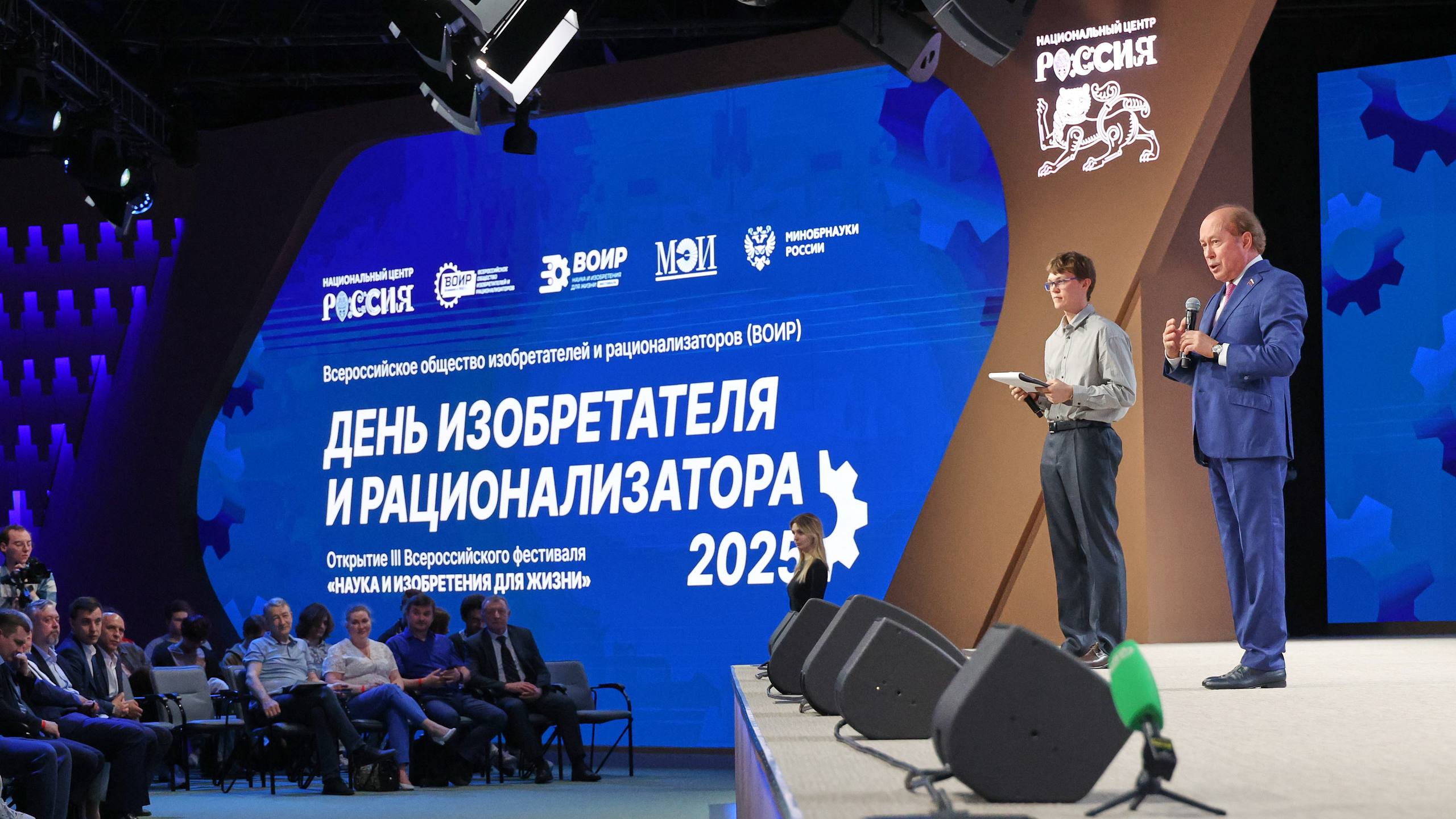В НЦ «Россия» дали старт III Всероссийскому фестивалю «Наука и изобретения для жизни» Фестиваль пройдет в 15 регионах страны и объединит более 400 тысяч единомышленников. Участников торжественной церемонии открытия поприветствовал заместитель Председателя Правительства РФ Дмитрий Чернышенко. Наш Президент Владимир Владимирович Путин утвердил новые национальные проекты технологического лидерства. Ключом к их успешной реализации является разработка и внедрение прорывных наукоемких технологий и решений. Именно ваши инновационные идеи и проекты помогают двигать вперед отечественную науку и промышленность, — сказал Дмитрий Чернышенко. Заместитель Председателя Комитета по науке и высшему образованию Госдумы Владимир Кононов подчеркнул, что особую символичность празднику придает его совпадение с Днем молодежи, ведь молодые специалисты — ключевой ресурс для обеспечения технологического лидерства нашей страны. Стратегия ВОИР до 2030 года делает ставку на молодежь. Мы видим растущий престиж профессии инженера, ученого и изобретателя, чему способствует и серьезная государственная поддержка — увеличение затрат на научно-исследовательские и опытно-конструкторские работы, предоставление льгот молодым изобретателям при поступлении в вузы и многое другое. Пусть этот фестиваль станет яркой демонстрацией мощи российской изобретательской мысли, — сказал Владимир Кононов. Одним из торжественных событий церемонии стало вступление в ряды изобретателей 13 молодых ученых и награждение заслуженных ученых ВОИР, которые внесли большой вклад в изобретательскую деятельность. «Россия»