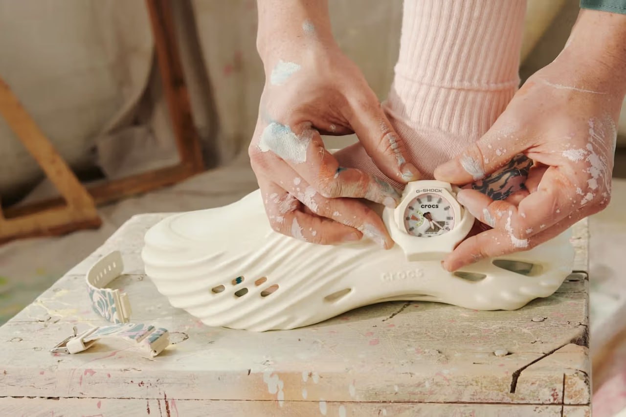 G-SHOCK и Crocs объединились в необычной коллаборации Casio и Crocs представили совместный проект, который соединяет мир часов и обуви. В рамках коллаборации создана модель Crocs Echo Wave с модульным корпусом часов G-SHOCK, который можно носить как на запястье, так и на обуви. Технически это работает просто: корпус часов можно снять с ремешка и установить на систему заклепок обуви. Кроксы получили мраморный ремешок для щиколотки, дизайн которого создан под впечатлением от классического стиля G-SHOCK. Интересная деталь — обувь обработана специальным составом и светится в темноте. Сами часы сохранили все стандартные функции линейки G-SHOCK: ударопрочную конструкцию, водонепроницаемость до 200 метров, поддержку мирового времени для 48 городов, секундомер, таймер, пять будильников и светодиодную подсветку. Модель поступит в продажу 27 мая 2025 года по цене 200 долларов ~16 000 рублей . В продаже будет ограниченное количество пар.