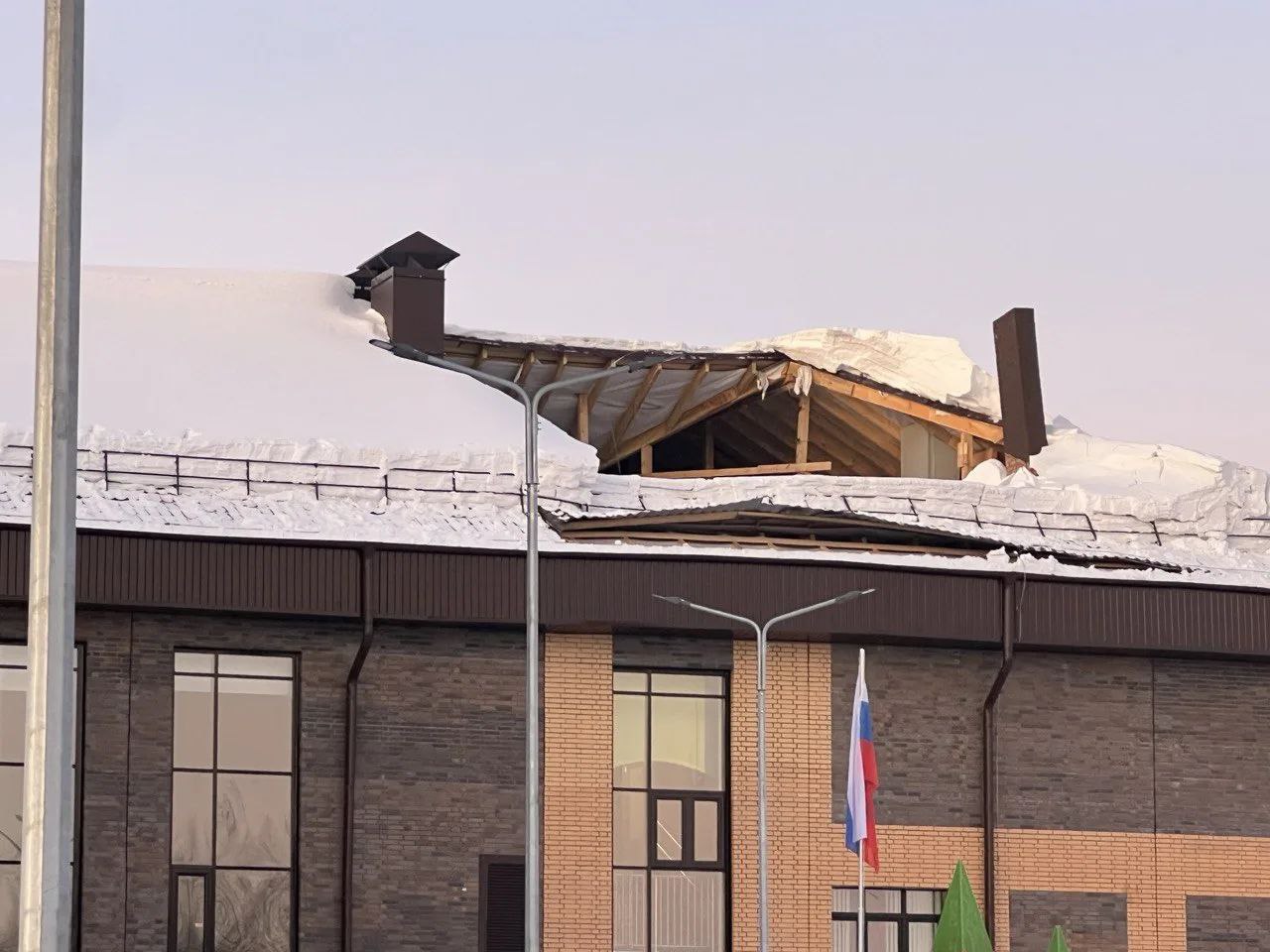 Крыша частично обрушилась у построенной три месяца назад школы в Новосибирской области В школе в селе Репьево Тогучинского района отменены занятия из за повреждения крыши Школу строил скандальный застройщик Ликстрой но власти заявили что крышу повредили рабочие Здание ввели в эксплуатацию в ноябре 2025 года Глава района Сергей Пыхтин сообщил что происшествие случилось при уборке крыши от снега На обнародованном фото снег на крыше лежит нет его только в месте повреждения и мало с краю В ходе работ по уборке снега привлеченными образовательным учреждением работниками была повреждена кровля здания Репьевской средней школы Главное никто из людей не пострадал Основные конструктивные элементы здания не повреждены написал Пыхтин в телеграме МЧС передает что поступило сообщение об обрушение части стропильной системы кровли здания школы в селе Репьево Тогучинского района В связи с происшествием занятия в школе 5 февраля отменены Мы приложим все усилия чтобы в кратчайшие сроки провести необходимый ремонт и устранить все последствия инцидента Ситуация находится под моим личным контролем добавил Пыхтин Старая школа в селе разваливалась и в 2022 году был заключен контракт на возведение школы за 430 млн рублей Работы обещали завершить к 1 сентября 2023 однако с тех пор срок выполнения неоднократно переносился рассказывали ранее общественники По данным властей её ввели в эксплуатацию в ноябре 2025 года Школа построена по госпрограмме Новосибирской области Развитие образования создание условий для социализации детей и учащейся молодежи в Новосибирской области Строительством занималось ООО Ликстрой Фирма помимо школы в Репьево сорвала сроки строительства школы в Сузуне Компания также упоминалась в связи с мошенничеством на десятки миллионов при возведении детского сада в Тогучине В числе обвиняемых Наталья Фазлыева владелица Ликстроя Начальницу отдела контрактной службы министерства строительства региона Ольгу Колмакову обвинили в получении взятки айфоном за лоббирование интересов Ликстроя