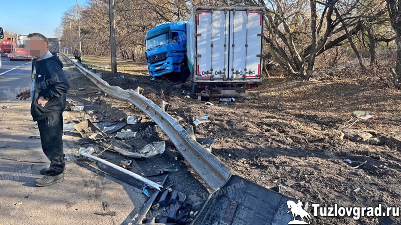 Вчера  17 ноября  около полудня на трассе М4 в Красном Колосе столкнулись два грузовика  По предварительной информации, тягач «ДАФ» без полуприцепа выехал на перекресток на свой зеленый сигнал светофора со стороны Красного Колоса и поворачивал налево в сторону Новочеркасска, но не в крайнюю левую полосу, как это предписано разметкой, а пересек сплошные и врезался в бок «Мерседеса» с полуприцепом, который двигался по трассе со стороны Ростова в правой полосе также на разрешающий сигнал светофора. После столкновения «Мерседес» откинуло на правую обочину, где он снес столб и часть металлического отбойника.  В результате ДТП никто не пострадал. Из-за ДТП в сторону Новочеркасска на трассе сразу же образовалась огромная пробка.