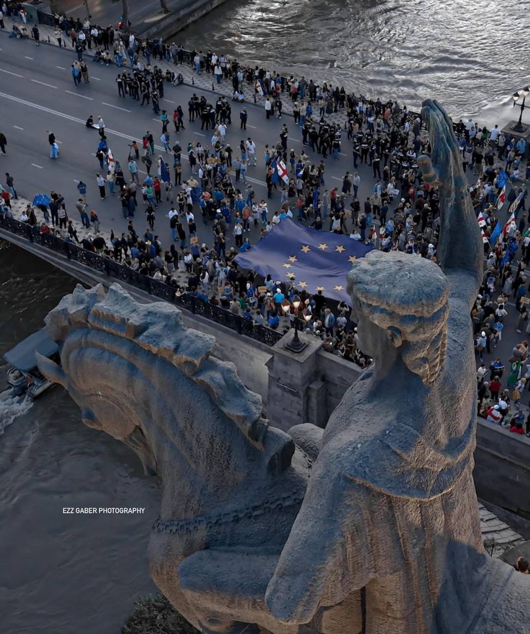 160-ый день протестов — в Тбилиси несколько тысяч митингующих дошли до площади Европы Участники шествия пришли на площадь Европы с флагами Евросоюза и Грузии. Митингующие растянули два больших флага у статуи Вахтанга Горгасали. СМИ сообщили, что на площади Европы установили китайские камеры с технологией распознавания лиц. В Тбилиси проходит ежегодное шествие в честь Дня Европы. Митингующие вышли в сторону площади Европы из разных локаций Тбилиси: площади Республики, площади Марджанишвили, здания Общественного вещателя и метро Авлабари. Подписаться Помочь RusNews