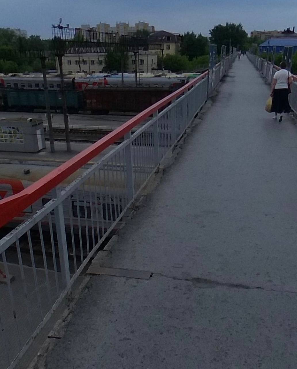 В Тюмени закроют пешеходный мост соединяющий вокзал и микрорайон Маяк Движение по мосту будет перерыто с 29 августа по 29 сентября Причина всему ремонт который уже давно напрашивался В планах отремонтировать лестничный сход и надземный переход со стороны улицы Привокзальная В настоящее время состояние моста оставляет желать лучшего ступени и площадки обветшали на них видны сколы что затрудняет передвижение пешеходов особенно с колясками и велосипедами Несмотря на это установка лифтов пока не планируется Более комфортный переход будет построен позже в рамках проекта нового тоннеля под железной дорогой