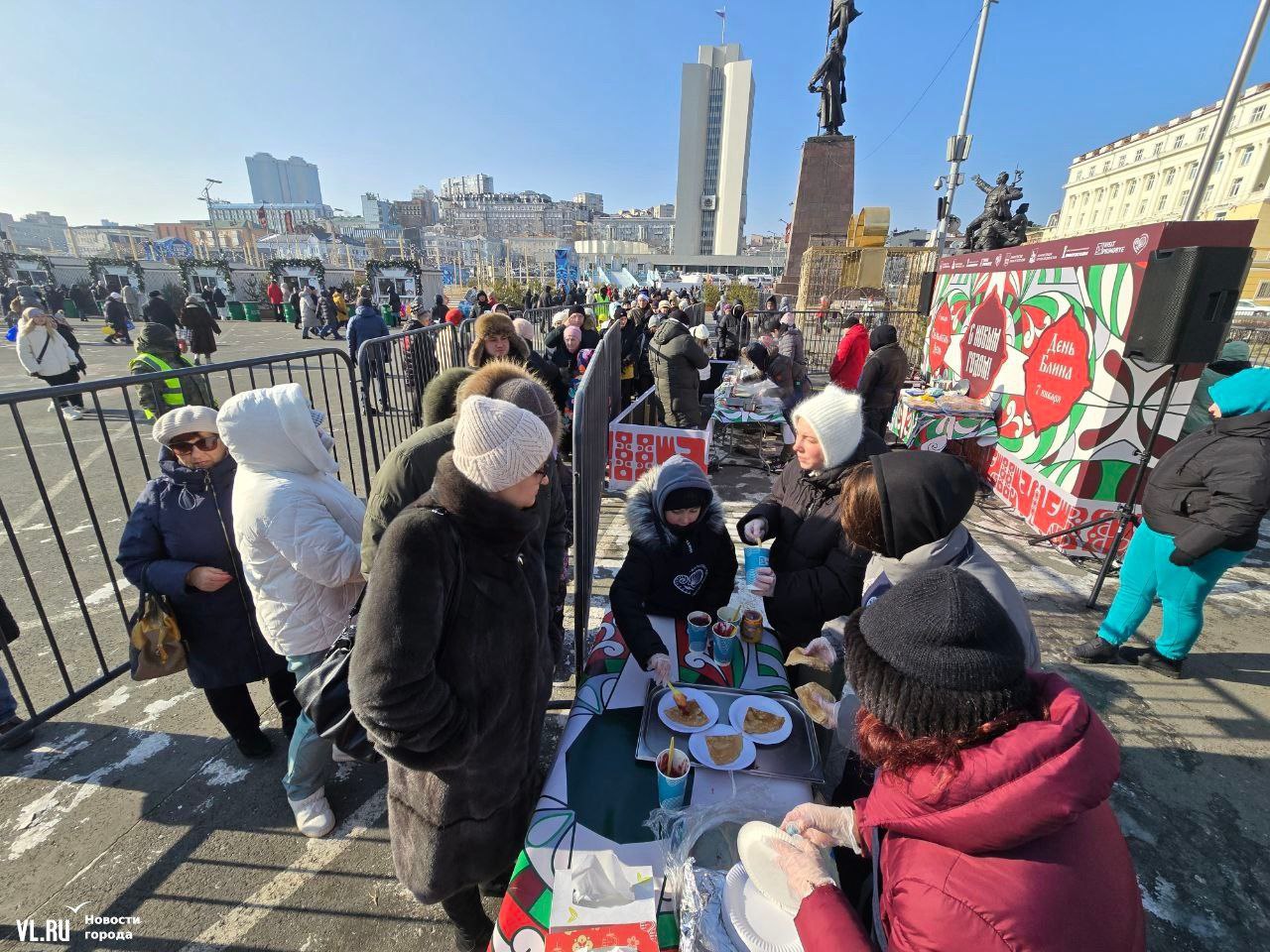 На центральной площади Владивостока стартовал День русского блина. Заметив растянувшуюся на десятки метров очередь, организаторы решили не тянуть и начать пораньше – на пяти заготовленных заранее сковородках уже вовсю жарят. Долго стоять в очереди не придется – тем, кто пришел заранее и прождал в очереди добрых полчаса, блины достанутся сразу, повара предварительно заготовили сотни «солнышек» из теста, которые при гостях поливают вареньем. Правда, стоящие в середине «змейки», уже пританцовывают и протирают носы платками.