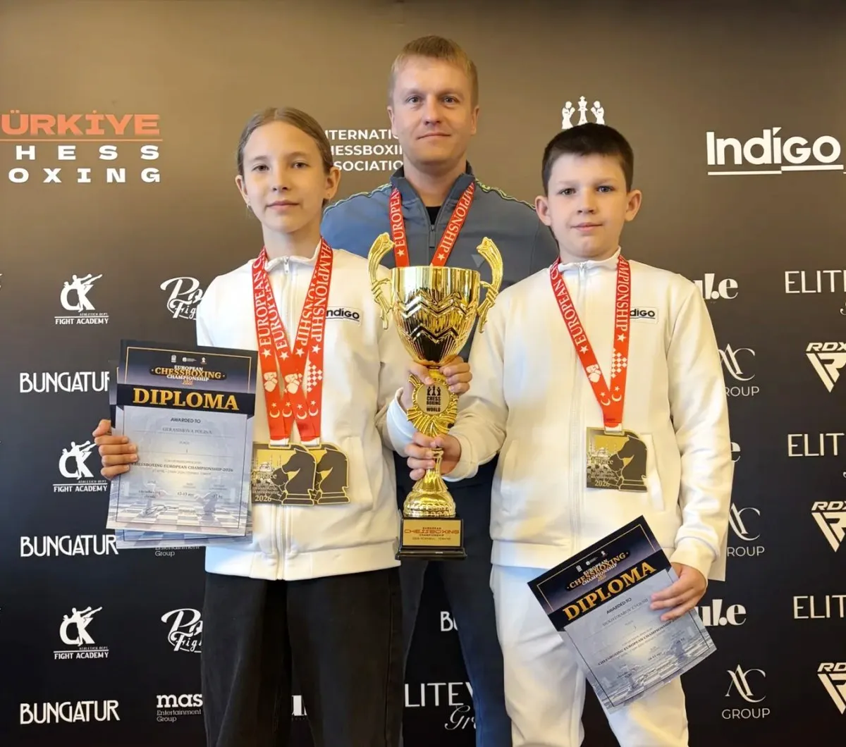 Двое школьников из Краснощёковского района выиграли чемпионат Европы по шахбоксу в Стамбуле Шахбокс вид спорта где участники соревнуются за шахматной доской и на боксёрском ринге В возрастной группе мальчиков 10 11 лет победителем стал Евгений Бухтояров Среди девочек 9 12 лет золотую медаль выиграла Полина Герасимова Оба юных спортсмена из Краснощёковского района где они занимаются боксом под руководством тренера Вадима Ковжуна Шахматную подготовку дистанционно провёл барнаульский тренер Евгений Арапов Краснощёковские шахбоксёры отобрались на чемпионат Европы став победителями первенства России в марте в Москве Как победители континентального первенства Евгений и Полина завоевали право выступить на чемпионате мира который пройдёт в октябре в Узбекистане Всего российские спортсмены завоевали в Стамбуле 52 золотых 30 серебряных и 25 бронзовых медалей пишет Алтайский спорт   Поздравить спортсменов Фото предоставлено Алтайскому спорту участниками соревнований