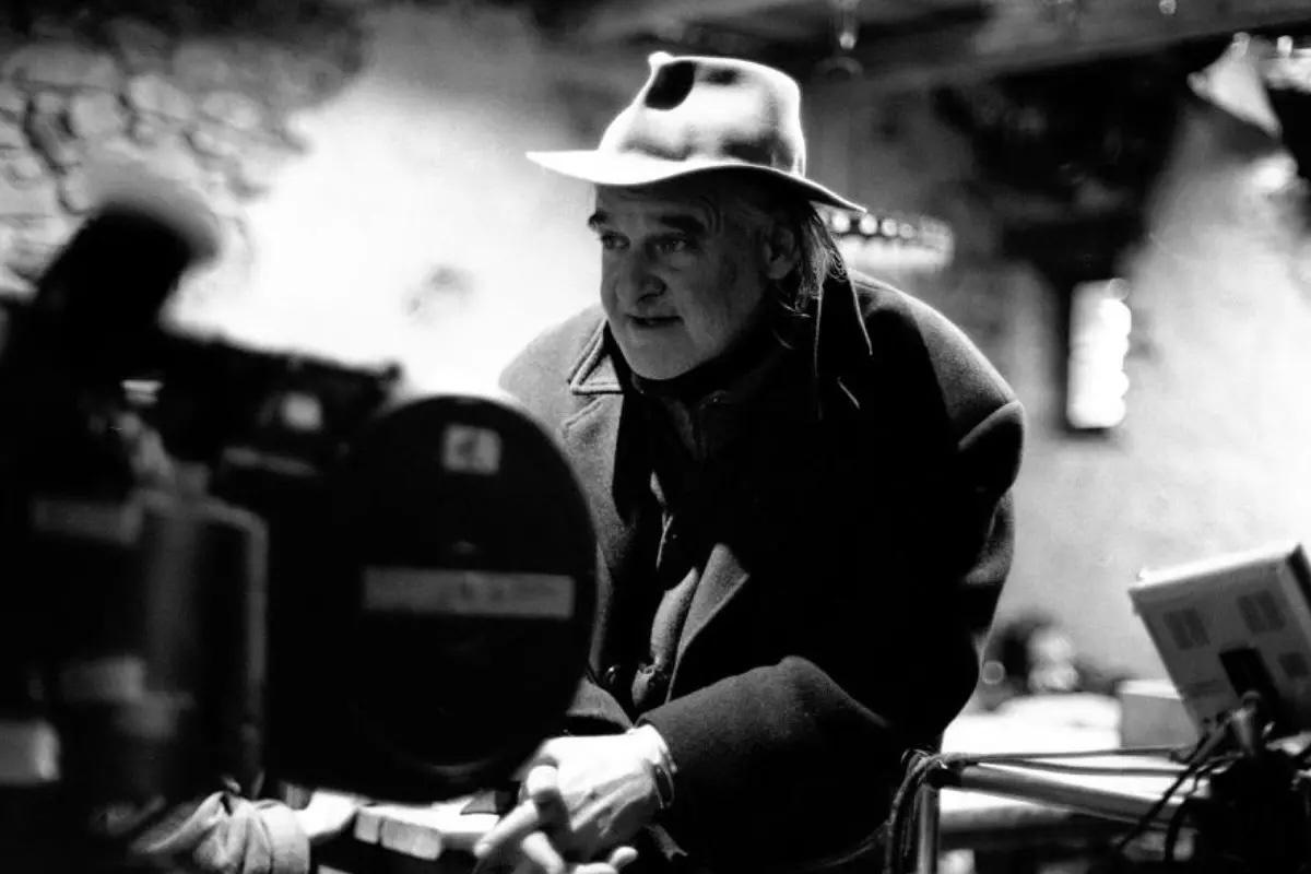 Умер Бела Тарр легендарный венгерский режиссёр Ему было 70 лет Бела Тарр стал одной из ключевых фигур европейского арт хаусного кино Он выстроил собственный легко узнаваемый кинематографический язык с предельно замедленным ритмом протяжёнными кадрами и концентрацией на экзистенциальных вопросах человеческого существования Его фильмы Сатанинское танго Гармонии Веркмайстера и Туринская лошадь со временем стали ориентиром для так называемого созерцательного кино и оказали глубокое влияние на несколько поколений режиссёров по всему миру