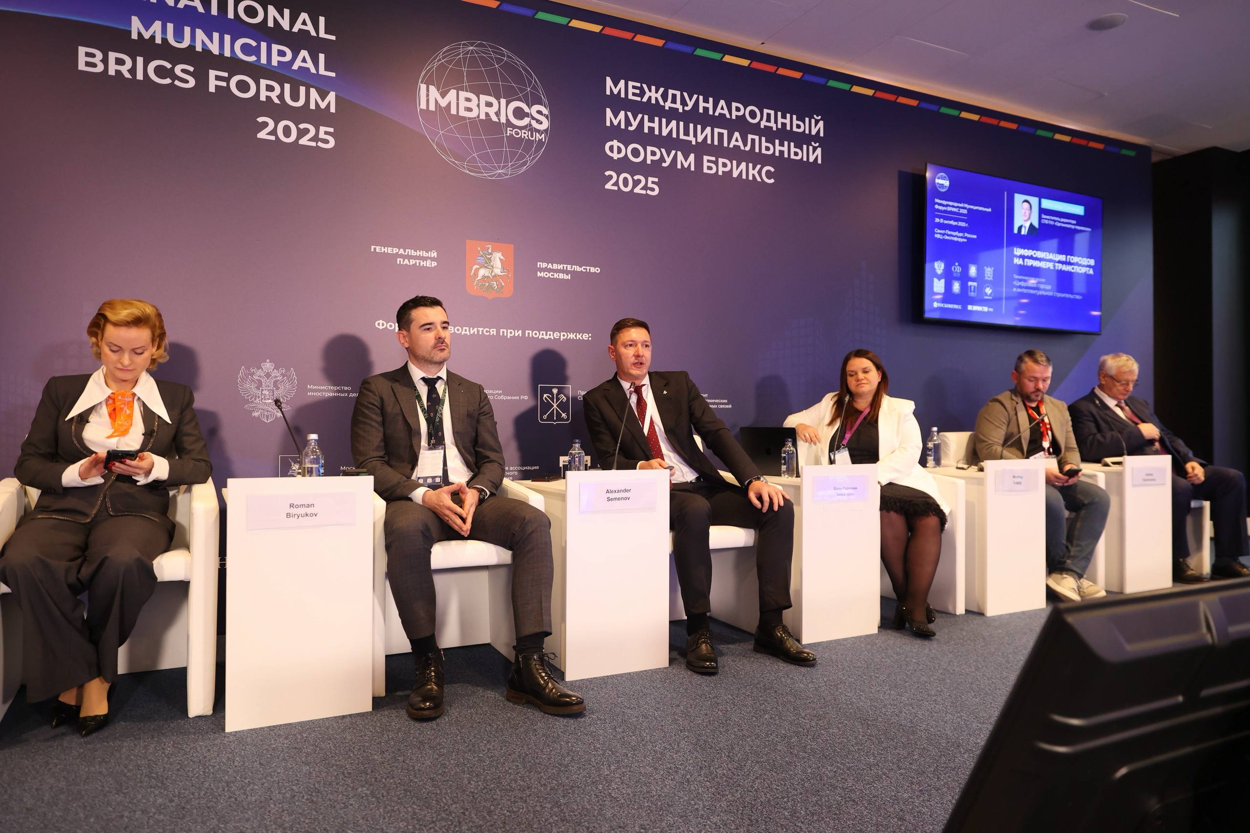Организатор перевозок представил транспортные цифровые сервисы Петербурга на Форуме БРИКС Заместитель директора СПб ГКУ Организатор перевозок Александр Семёнов выступил с докладом на Международном Муниципальном Форуме БРИКС 2025 В рамках тематической сессии Цифровые города и интеллектуальное строительство он рассказал как Санкт Петербург отвечает на запросы пассажиров и превращает общественный транспорт в современный технологичный и комфортный сервис В основе этих изменений масштабная цифровизация  98 5 доля электронных платежей за проезд в городе  100 транспорта оборудовано для их приема  весь новый подвижной состав оснащен датчиками пассажиропотока системами помощи водителю и бортовыми компьютерами Уже сейчас можно оплачивать проезд через мобильное приложение с полным тарифным меню города Скоро в приложении появится возможность оформлять льготные проездные не посещая пункты продаж Уже в следующем году будет запущен сервис оплаты по геопозиции В разработке новые виды билетов для бесшовной интеграции железнодорожного транспорта в городскую сеть Ключевые задачи которые стоят перед отраслью  подготовка кадров необходим новый уровень квалификации для работы с технологиями импортозамещение задача не просто заменить ПО и оборудование а сделать это без потери качества Так например мы нашли решение для пользователей Apple несмотря на ограничения NFC привел пример Семёнов надежность связи ведутся работы по обеспечению бесперебойной работы систем навигации и оплаты даже в условиях нестабильного мобильного интернета Особый акцент был сделан на использовании ИИ огромные массивы накопленных данных открывают колоссальные перспективы для оптимизации маршрутов прогнозирования пассажиропотока и повышения безопасности Я уверен что мы успешно справимся с любыми вызовами и пассажиры будут с удовольствием пользоваться удобным комфортным и безопасным транспортом Санкт Петербурга подвел итог Александр Семёнов