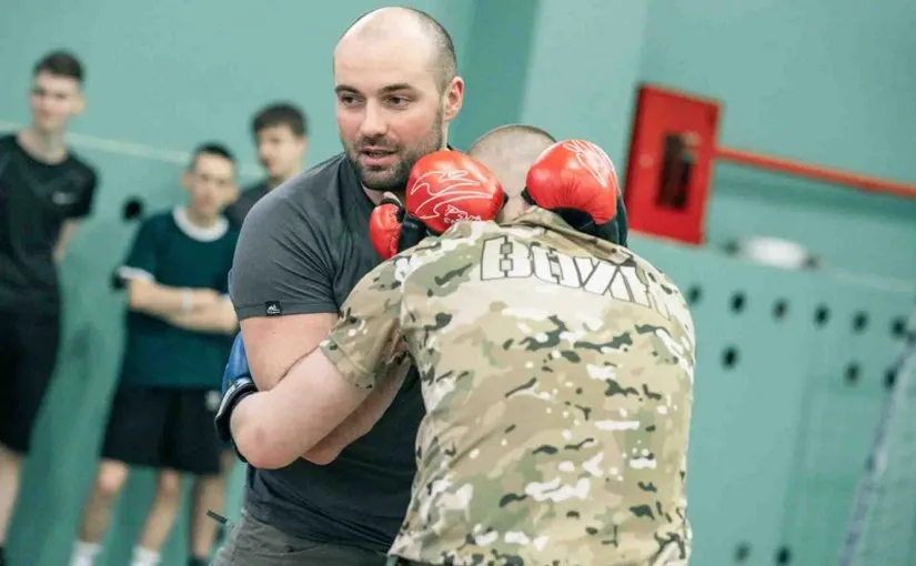На Камчатке запустили новый курс по самообороне Программа Самооборона 1 уровень разработанная Центром ВОИН совместно с Российским союзом боевых искусств реализуется в камчатском филиале Центра Она учит молодых людей от 14 до 35 лет навыкам защиты передаёт ИА Камчатское время Как подчеркнул заместитель председателя Правительства РФ полномочный представитель Президента РФ в ДФО председатель Наблюдательного совета Центра ВОИН Юрий Трутнев новая программа не только развивает физические качества курсантов но и учит их ответственности за себя за своих близких и свою страну Программа объёмом 36 академических часов сочетает практику и теорию Курсанты изучают технику борьбы способы защиты от вооружённого противника и учатся действовать в стрессовых ситуациях Особый акцент на умении оценить угрозу и избежать конфликта а не просто дать отпор По словам директора камчатского филиала Александра Бурхавецкого ключевая цель программы научить человека выиграть время и сохранить безопасность Главное не нокаутировать противника а успеть уйти от опасности Кроме физической подготовки курс охватывает психологию конфликтов и правовые аспекты самообороны Участники узнают где проходит граница допустимой силы и как действовать в рамках закона В будущем программа получит продолжение разрабатываются ещё три уровня подготовки Они будут направлены на развитие выносливости дисциплины и стрессоустойчивости