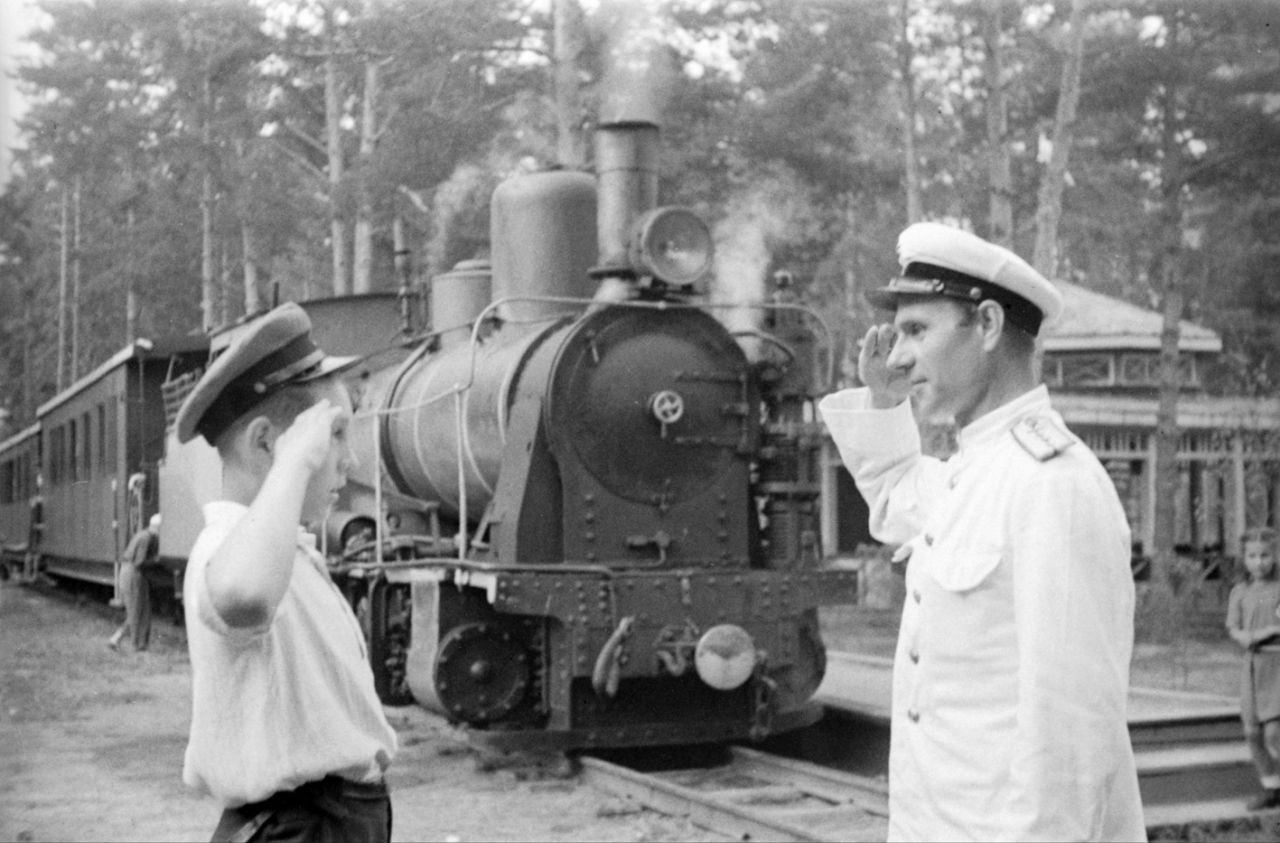 Решили сделали Ровно 90 лет назад 30 октября 1935 года в Центральном доме культуры железнодорожников состоялся первый слёт юных строителей Детской железной дороги Его участниками стали более 2 тыс учащихся железнодорожных школ Быковского и Раменского районов Московской области Именно на этом слёте было решено строить Московскую детскую железную дорогу Сказано сделано Уже 24 июня 1936 года в одном из самых живописных уголков Подмосковья в лесопарковой зоне посёлка Кратово начались работы по прокладке малой магистрали Взрослым строителям которые отсыпали земляное полотно укладывали шпалы и рельсы отсыпали балласт и делали выемки активно помогали юные железнодорожники Общими усилиями уже к 7 ноября 1936 года было завершено строительство 2300 м путей с шириной колеи 750 мм На субботниках комсомольцы депо Москва Пассажирская отремонтировали для ребят паровоз серии ВЛ 1 а их товарищи с Перовского вагоноремонтного завода подарили три пассажирских вагона И 2 мая 1937 года станционный колокол малой магистрали возвестил о готовности к отправлению по ней первого пассажирского поезда Так началась увлекательная жизнь на Московской детской железной дороге которая и сегодня продолжает оставаться настоящей кузницей кадров для столичной магистрали